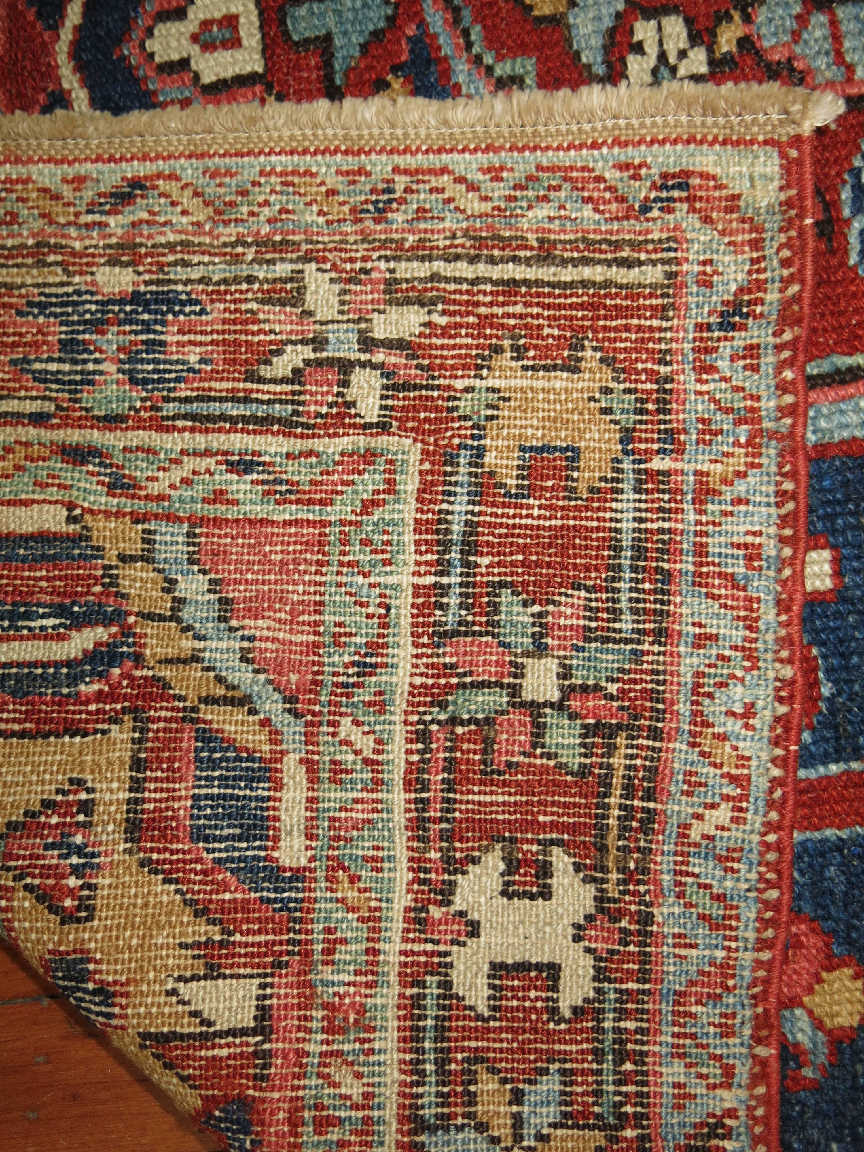 Rare square shaped Persian Heriz Rug. Main color accents in navy blue, gold and rusts.
