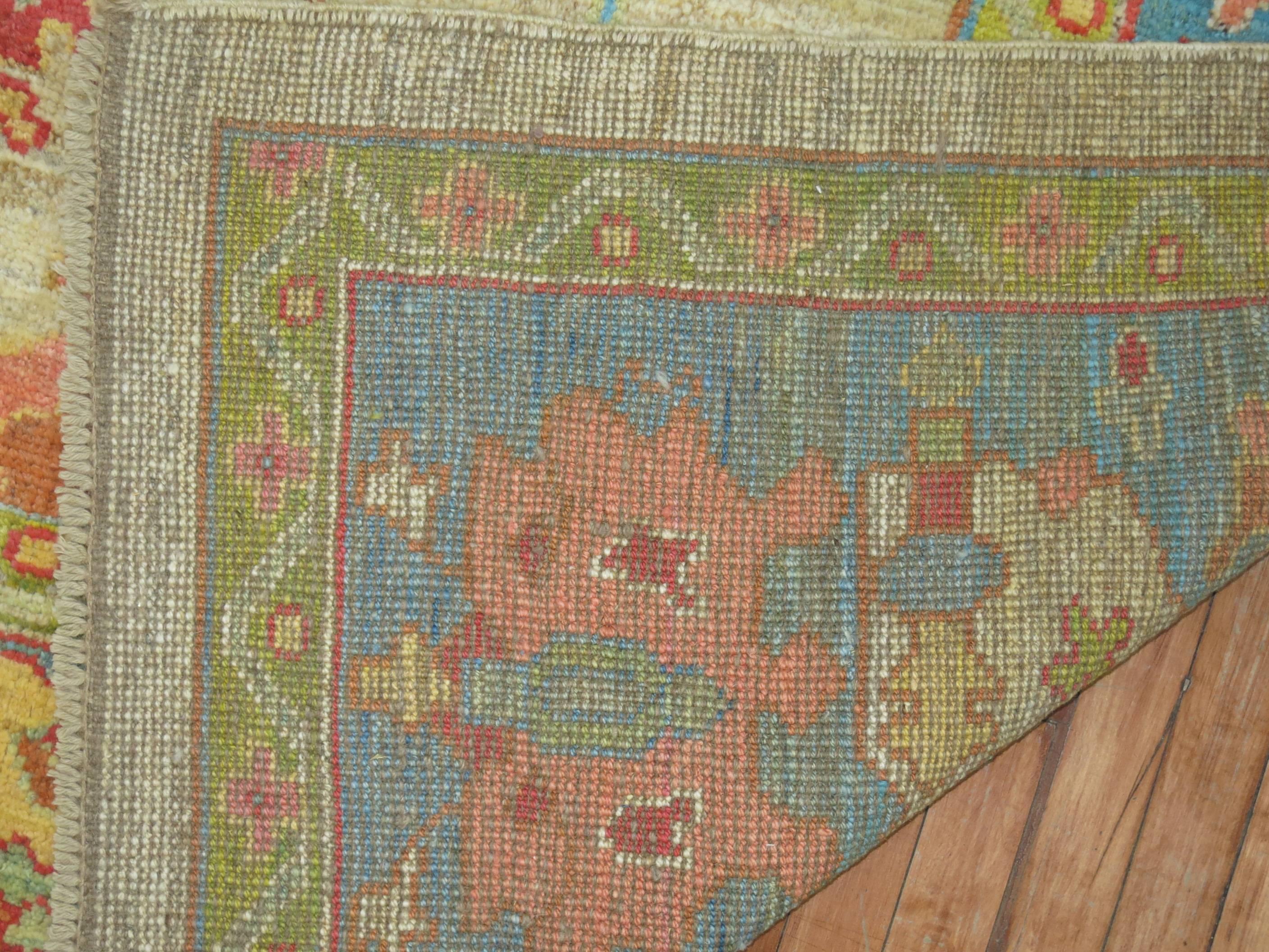 Beautiful Turkish Oushak rug featuring accents in green, blue and pinks on an abrashed ivory colored field.