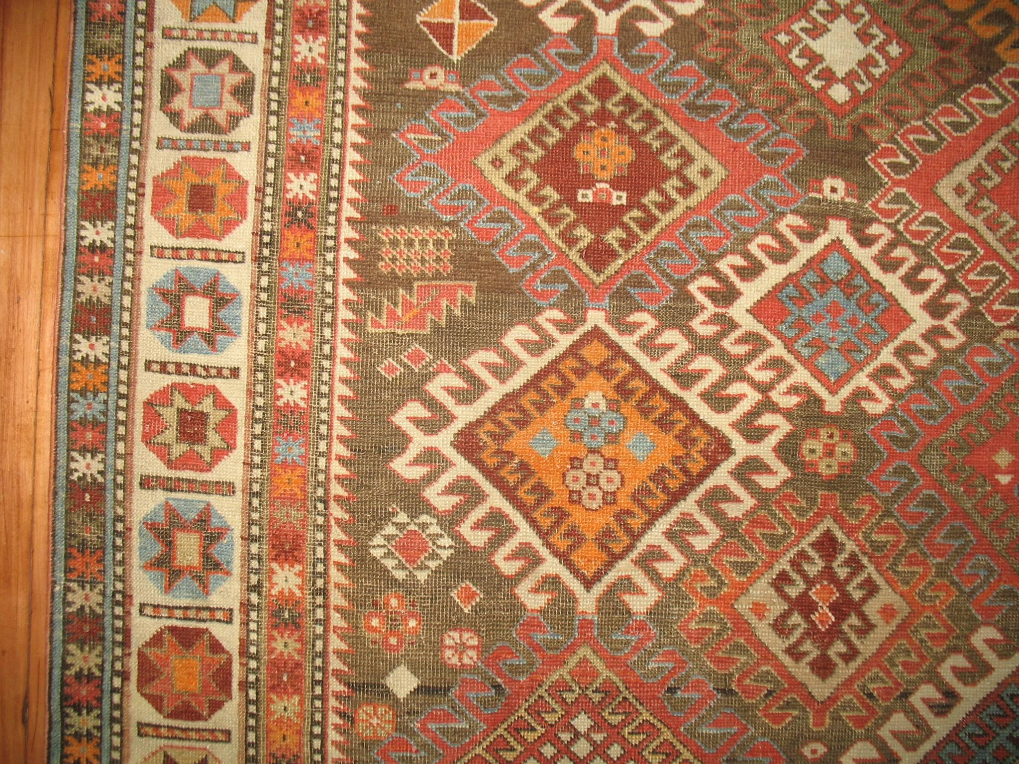 An early 20th century Caucasian Shirvan rug with an abrashed navy and brown field with accents in orange, lavender and blues.
Antique Caucasian Shirvan rugs offer original geometric ornamentation with a great graphic impact. As in so many of the