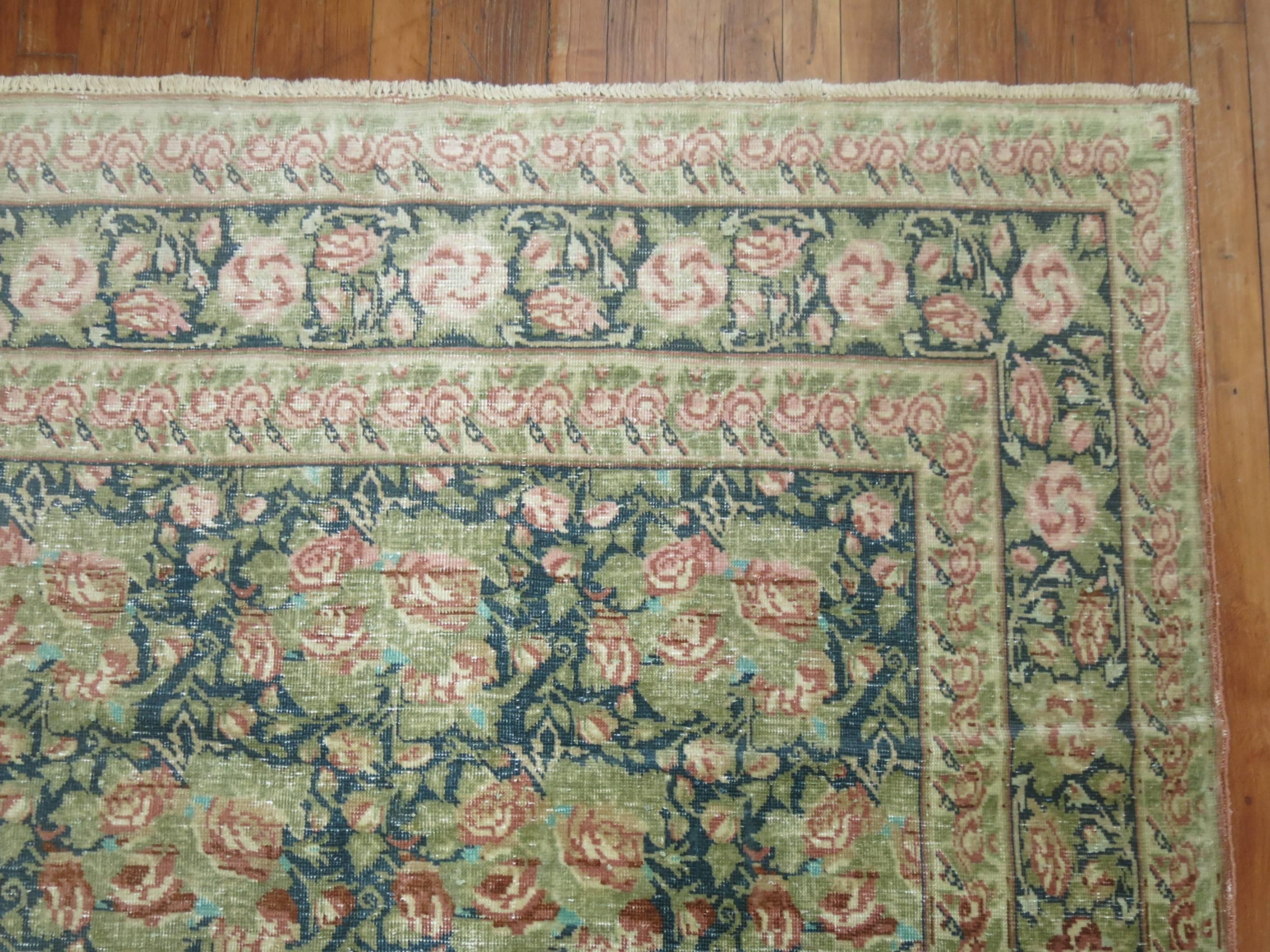 Worn mid-20th century European carpet with a matching floral field and motif in dominant green and pink shades.

Measures: 9'10'' x 13'.