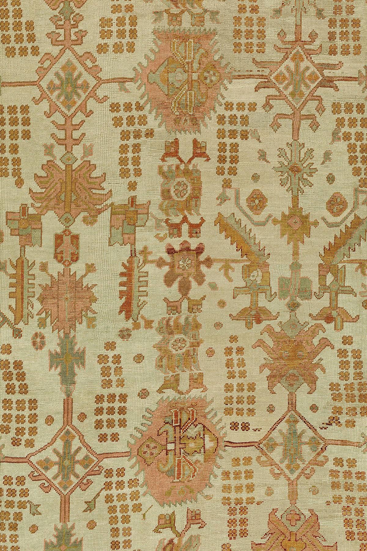 Antique Oushak carpet with an ivory colored ground, accents in pumpkin orange and teal.

Oushak in western Turkey has been a major center of rug production from the very beginning of the Ottoman period. Many of the great masterpieces of early