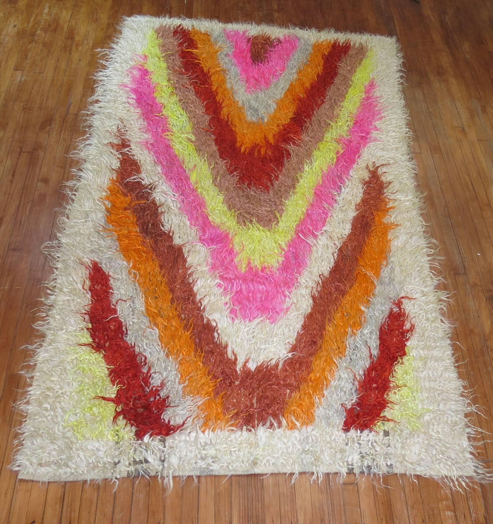 Bright and vibrant area size mid-20th century one of a kind decorative Turkish Tulu Yatak shag rug. Accents in pink, orange, rust, white, beige, red and neon green yellow.