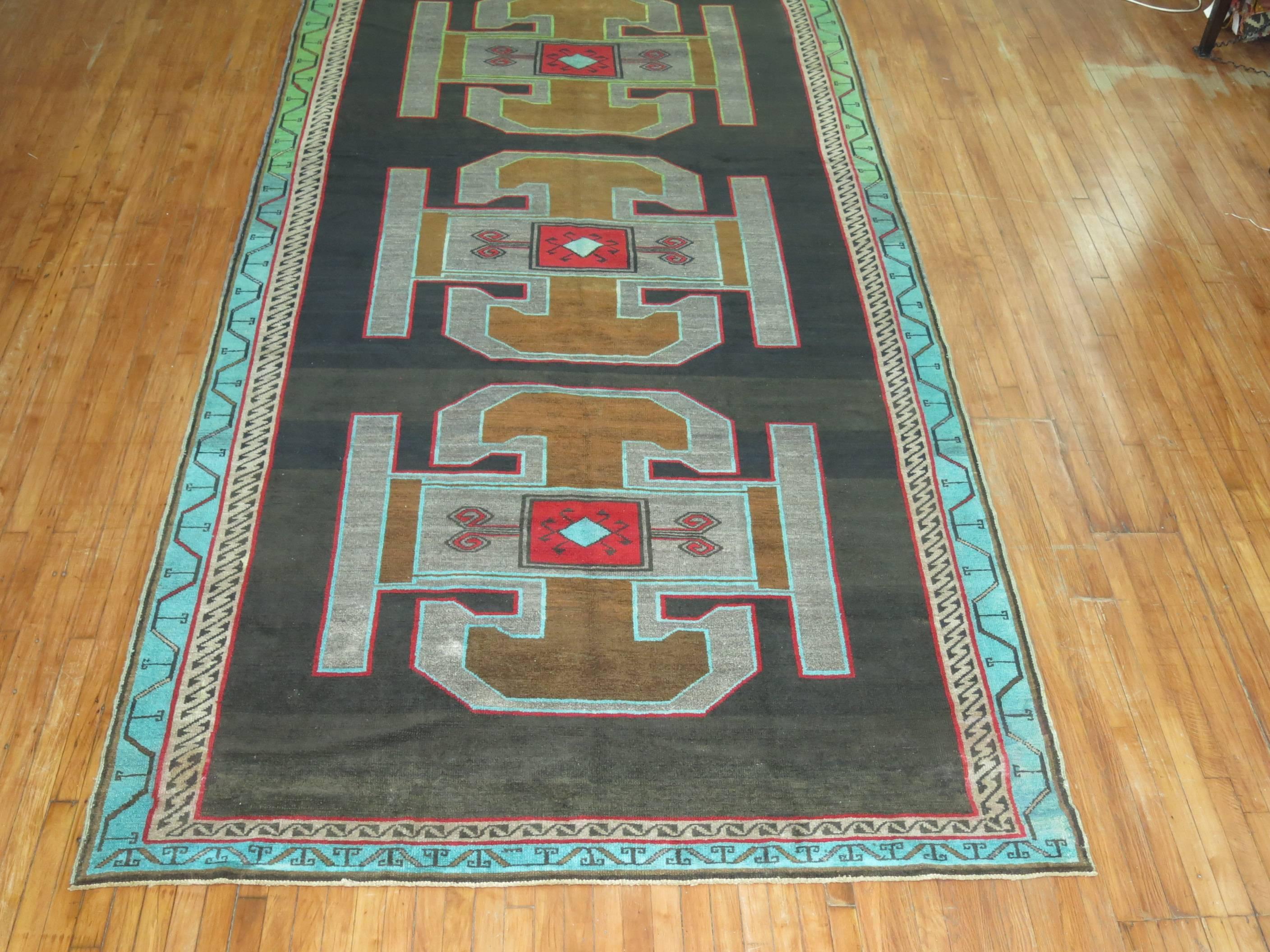 Electric colored mid-20th century Turkish Kars rug.

Kars is a village located in Northeast of Turkey. The weavers in this area tend to make long runners and long odd size gallery rugs, with large medallions often in the form of large Caucasian
