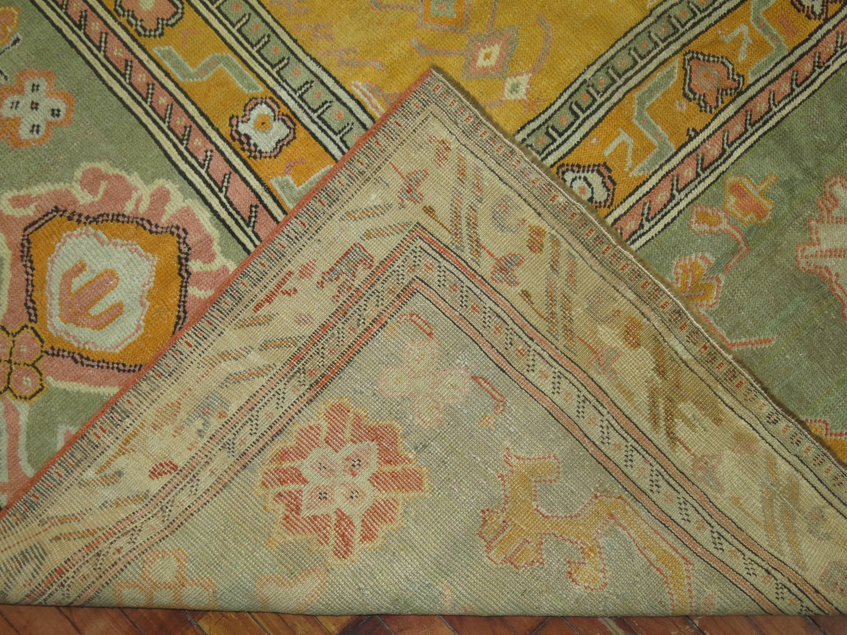 An early 20th century Turkish Ghiordes carpet with an all-over sunny yellow motif and green border.

Measures: 12'6