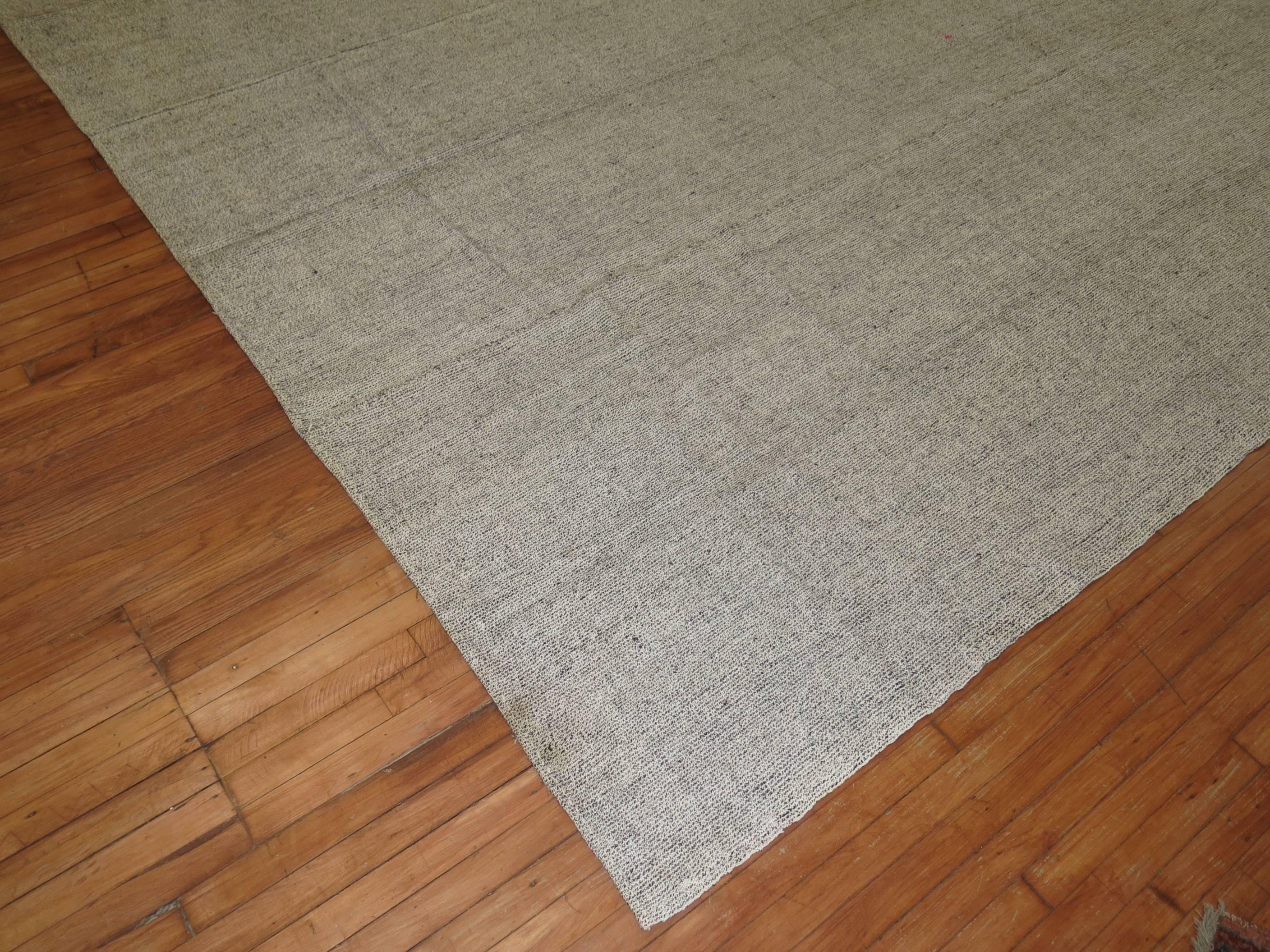 Plain solid gray one of a kind Turkish Kilim with small specs in black.

10' x 14'1''