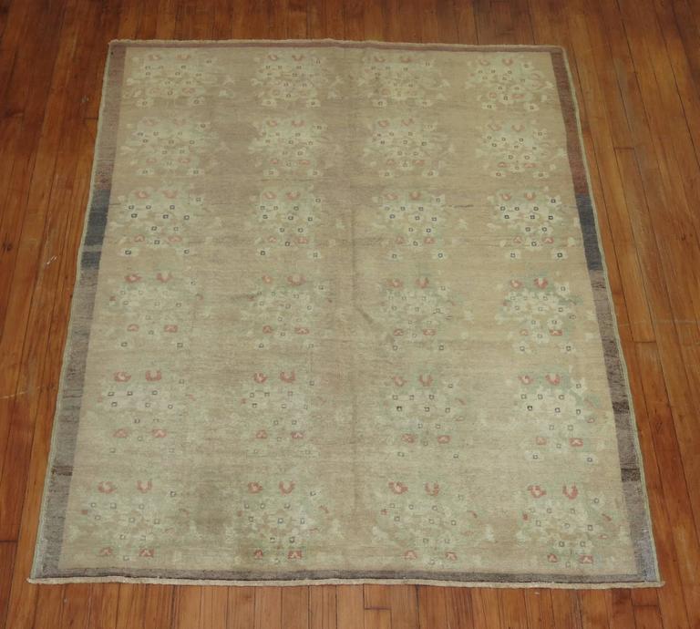 Mid-Century one of a kind Turkish rug with casual floral motif in camels, soft green and apricot surrounded by a soft brown thin border.

4'6''x  5'7''