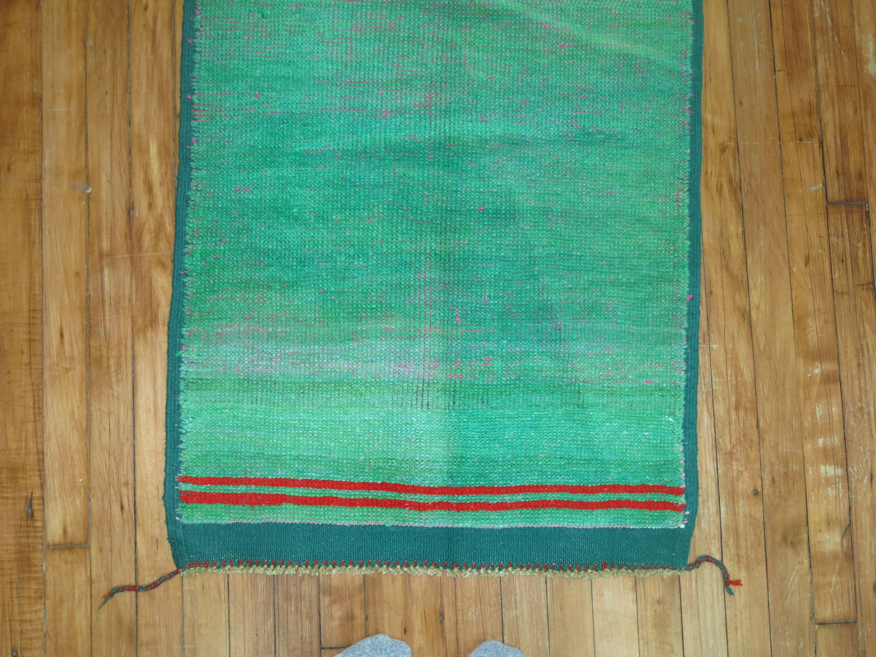 One of our most interesting finds recently this eclectic one of a kind vintage Anatolian with a plain solid green field with two red horizontal red stripes on one end. The texture and patina make this piece even more compelling too.

2'3'' x 4'10''