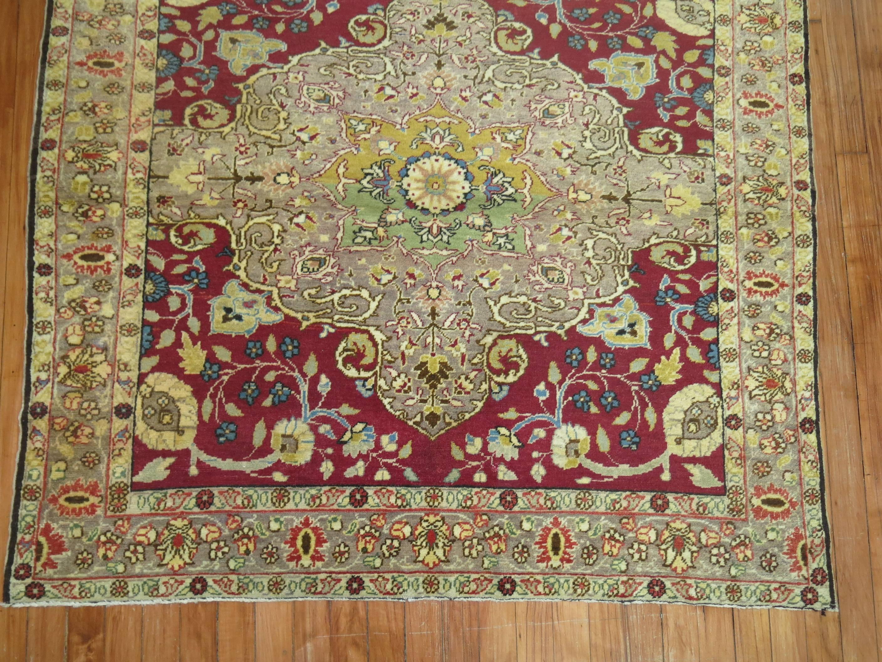 One of a kind rare original size antique Sivas rug with a raspberry colored ground and gray medallion and border with accents in blue, soft green and soft yellow.