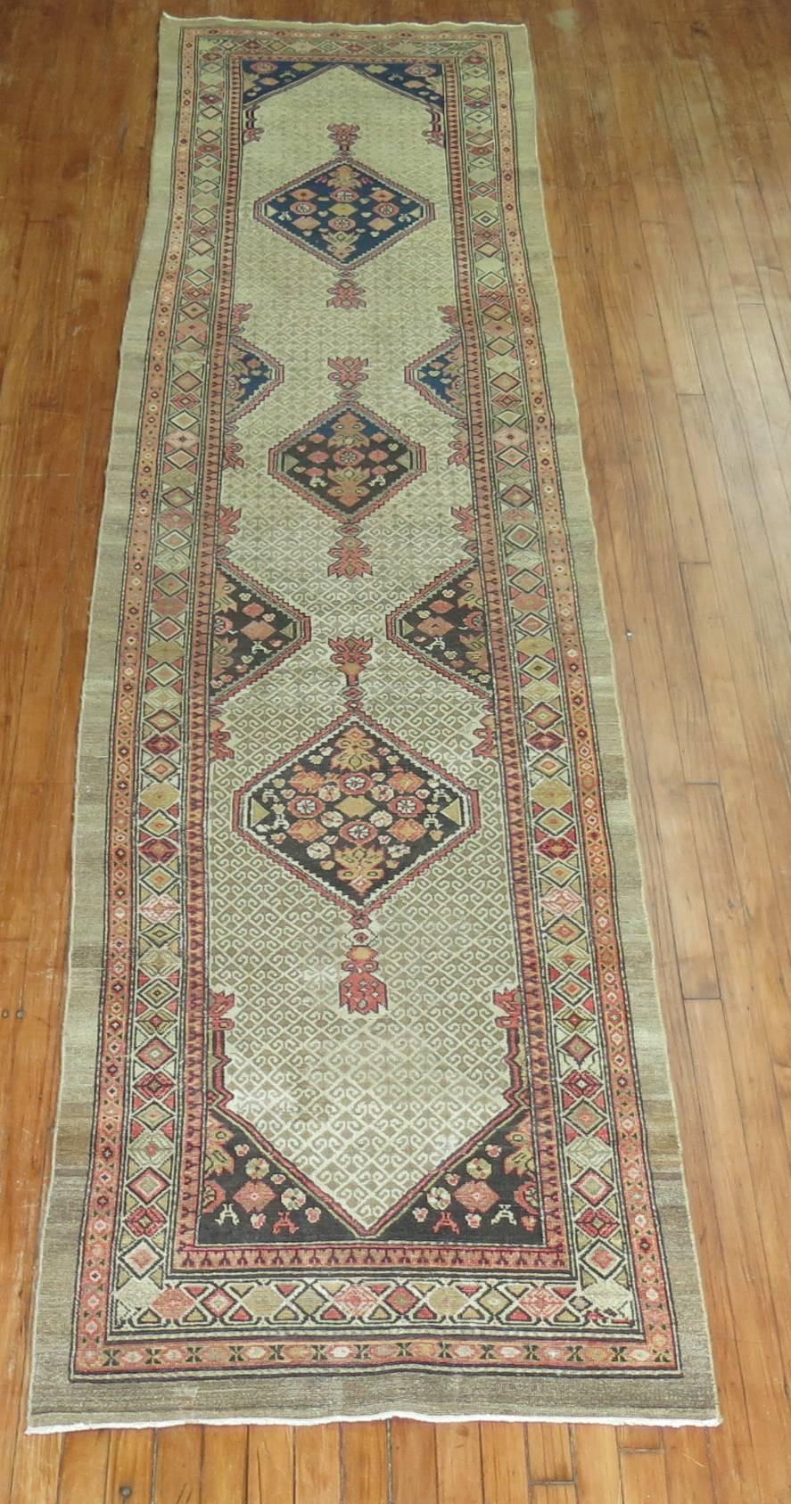 An authentic early 20th century Persian Serab runner with a triple medallion geometric motif predominantly in camel and blue.