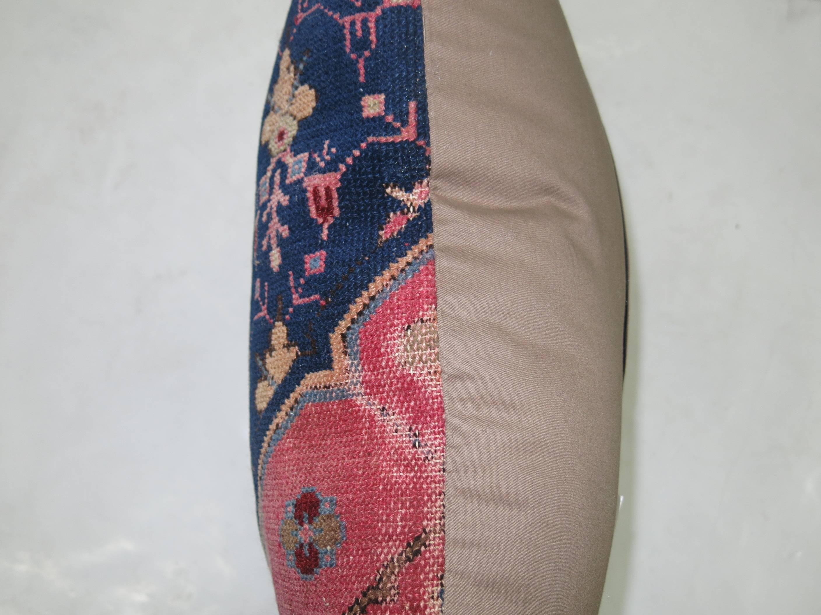 Antique Persian rug pillow in navy and pink.