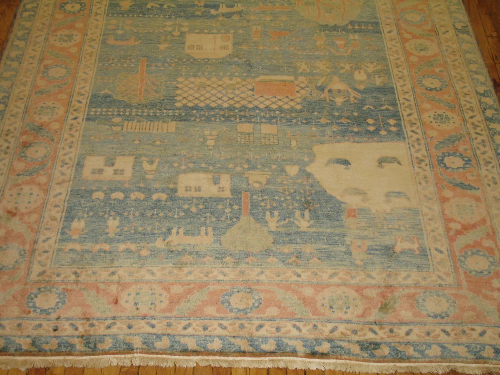 One of kind Turkish pictorial carpet with a soft blue background and peach border.