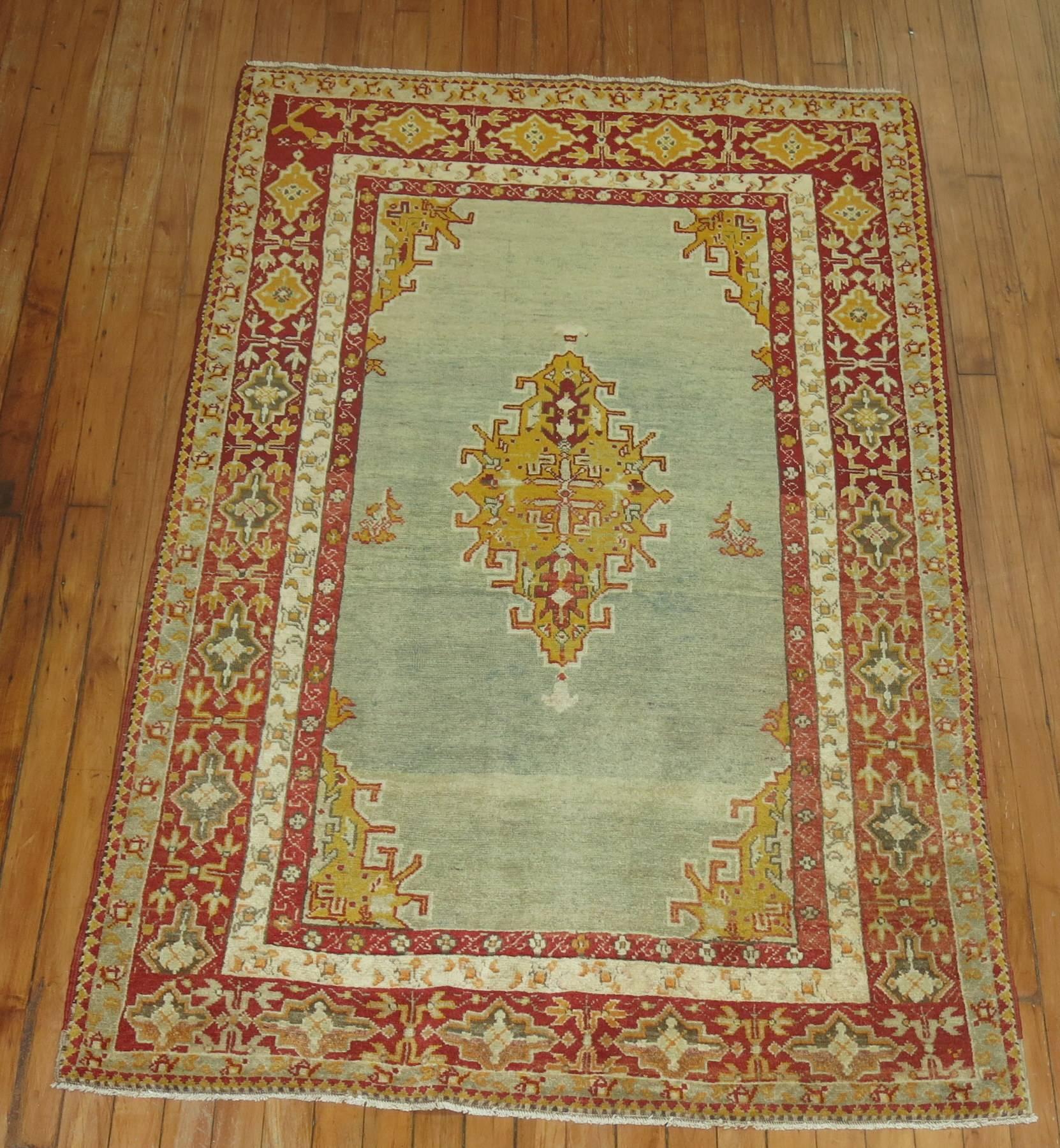 An early 20th century Turkish Sivas rug with an open field medallion pattern on a grayish blue field and cherry red predominant border. The rug is finely woven compared to other Turkish rugs of its type. Would make for a great wall covering as well.