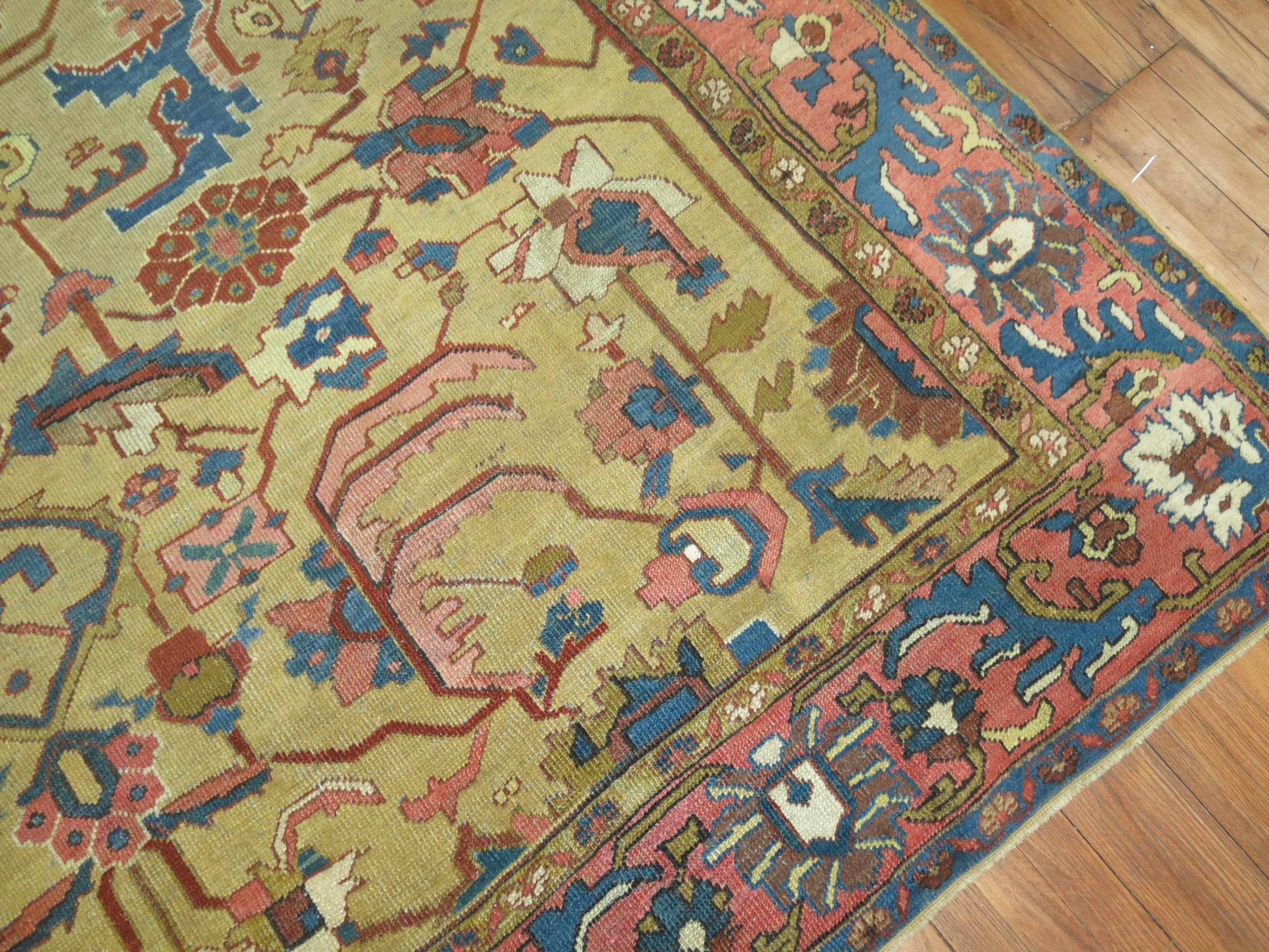 Early 20th century Persian Heriz carpet featuring an unusual mustard color ground. Predominant accents in blue and terracotta.

8'9'' x 12'1''