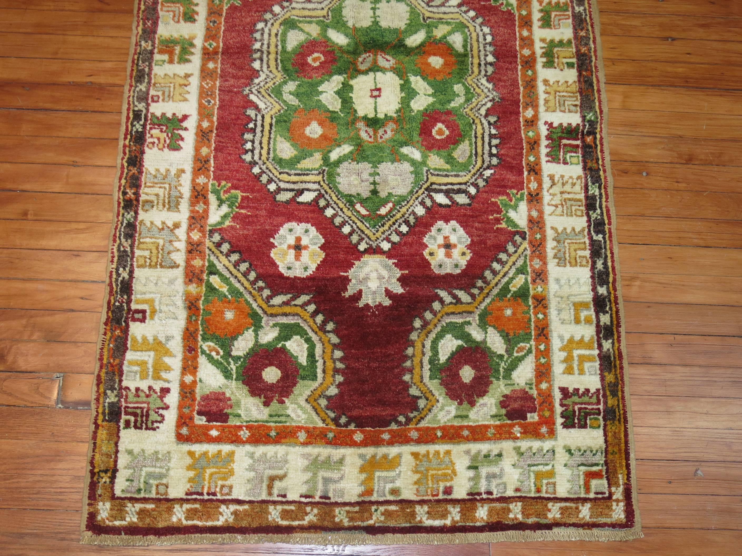 Turkish Oushak with a deep red ground, forest green medallion and ivory border.