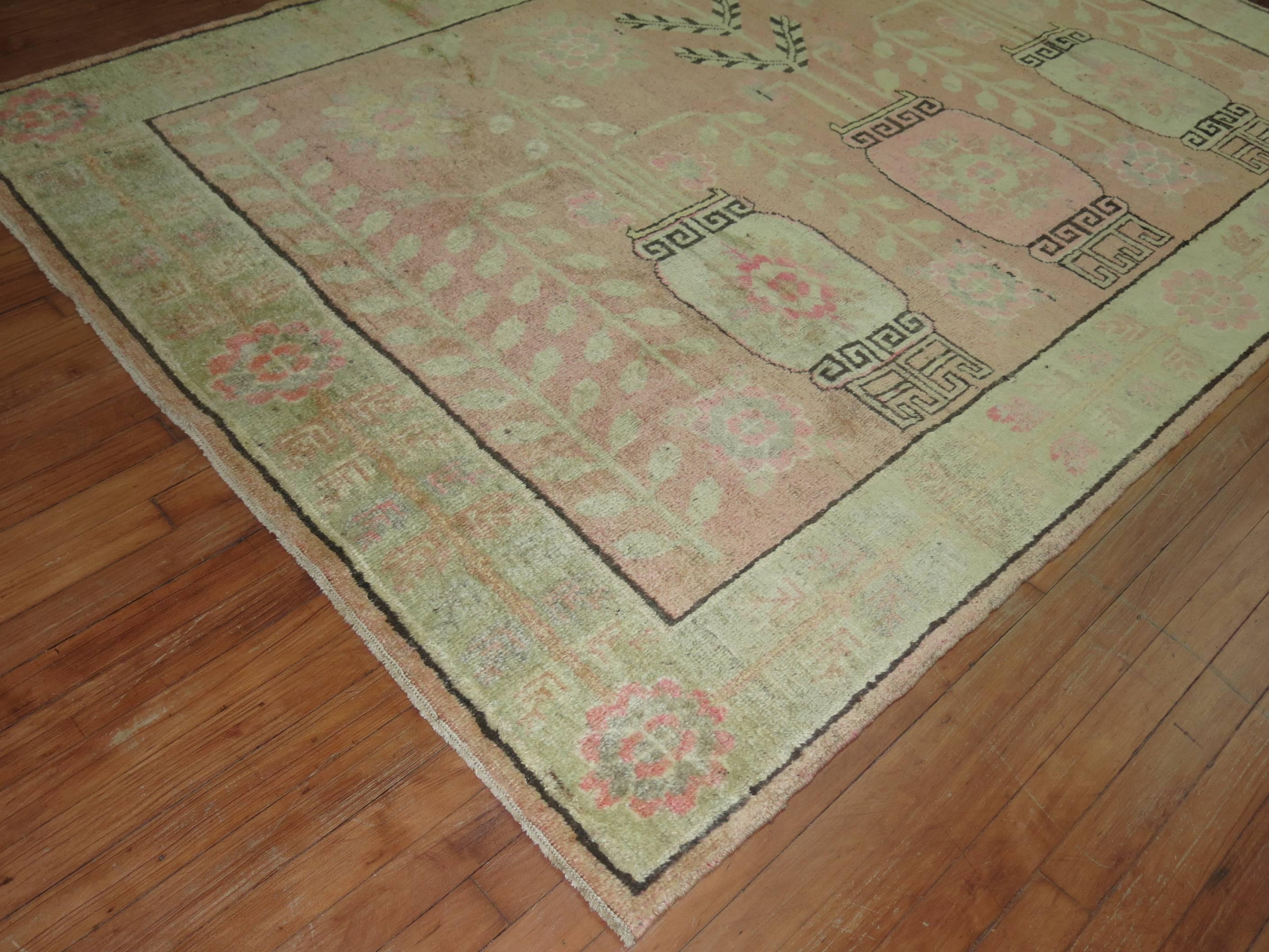Alfombra Khotan única en su género, con un suave campo rosa formado por un motivo de jarrón de flores y un suave borde verde.