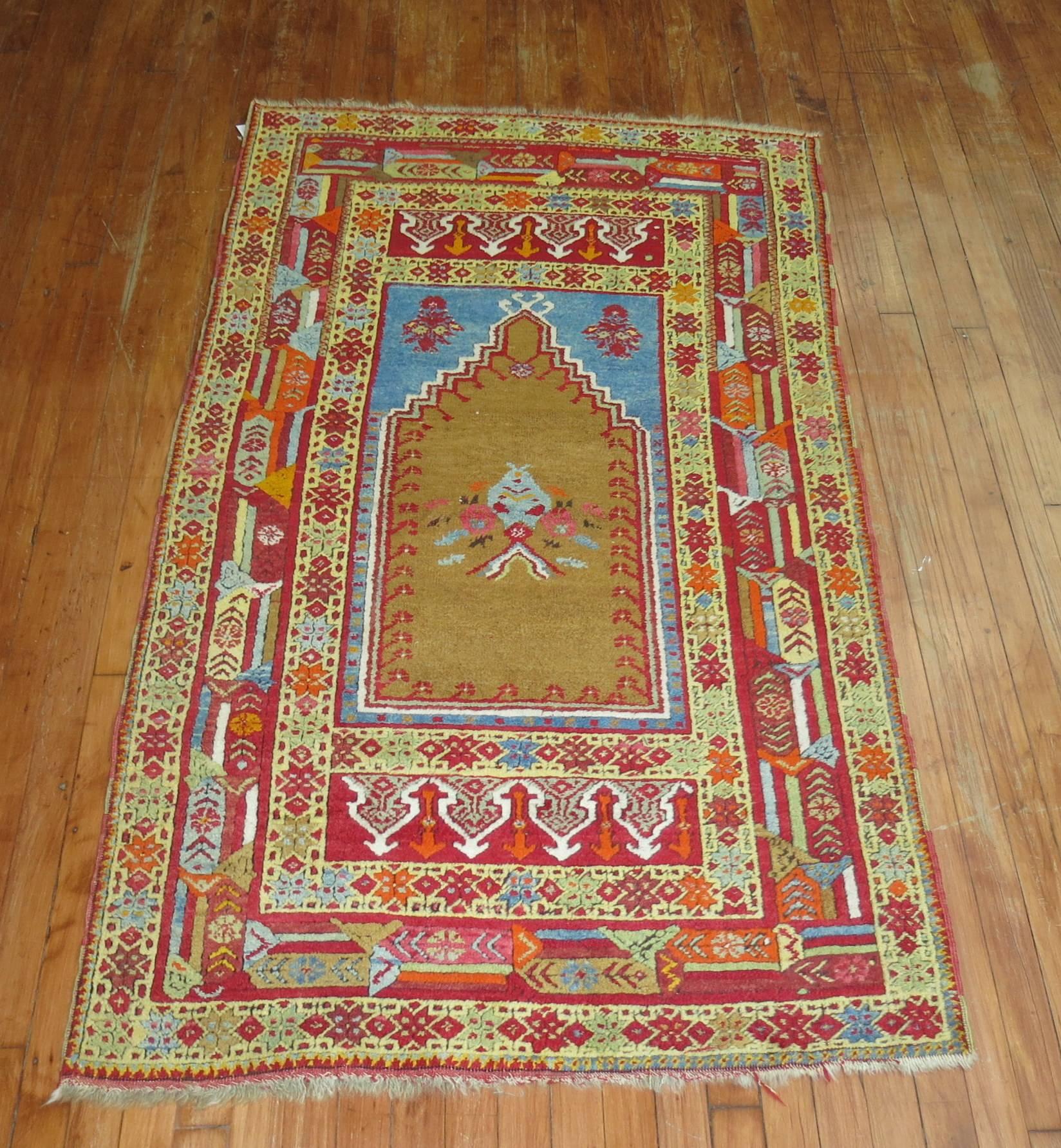 Colorful Directional antique Turkish Prayer rug. The multi-dimensional border on this piece is quite fascinating . We also love the French blue accent we don't typically find in rugs from this region. Would make a great wall piece too.