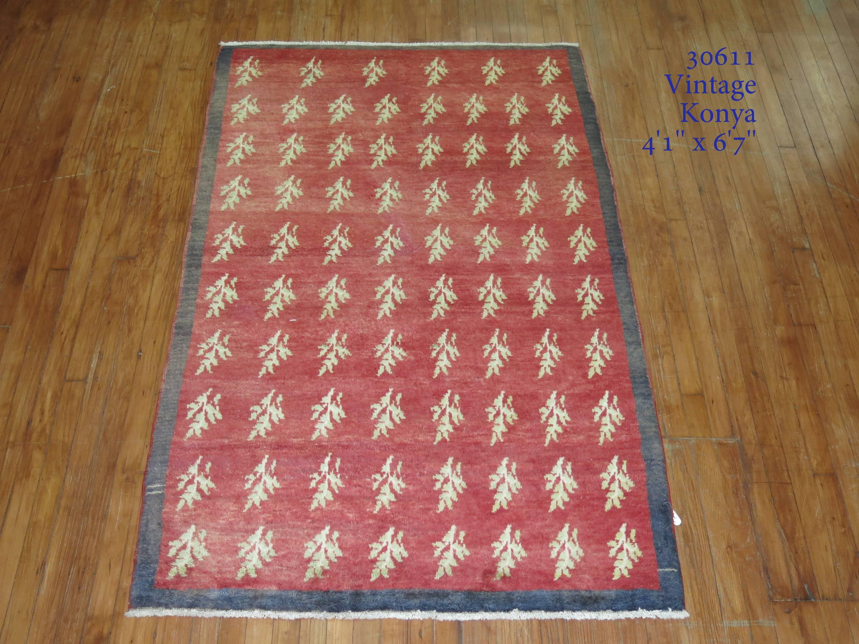 Türkischer Konya-Teppich aus der Jahrhundertmitte mit rotem Plüschflor und kohlefarbener Bordüre. Ein hübsches, sich ständig wiederholendes Motiv aus Zweigen und Blättern.

4'1'' x 6'7''