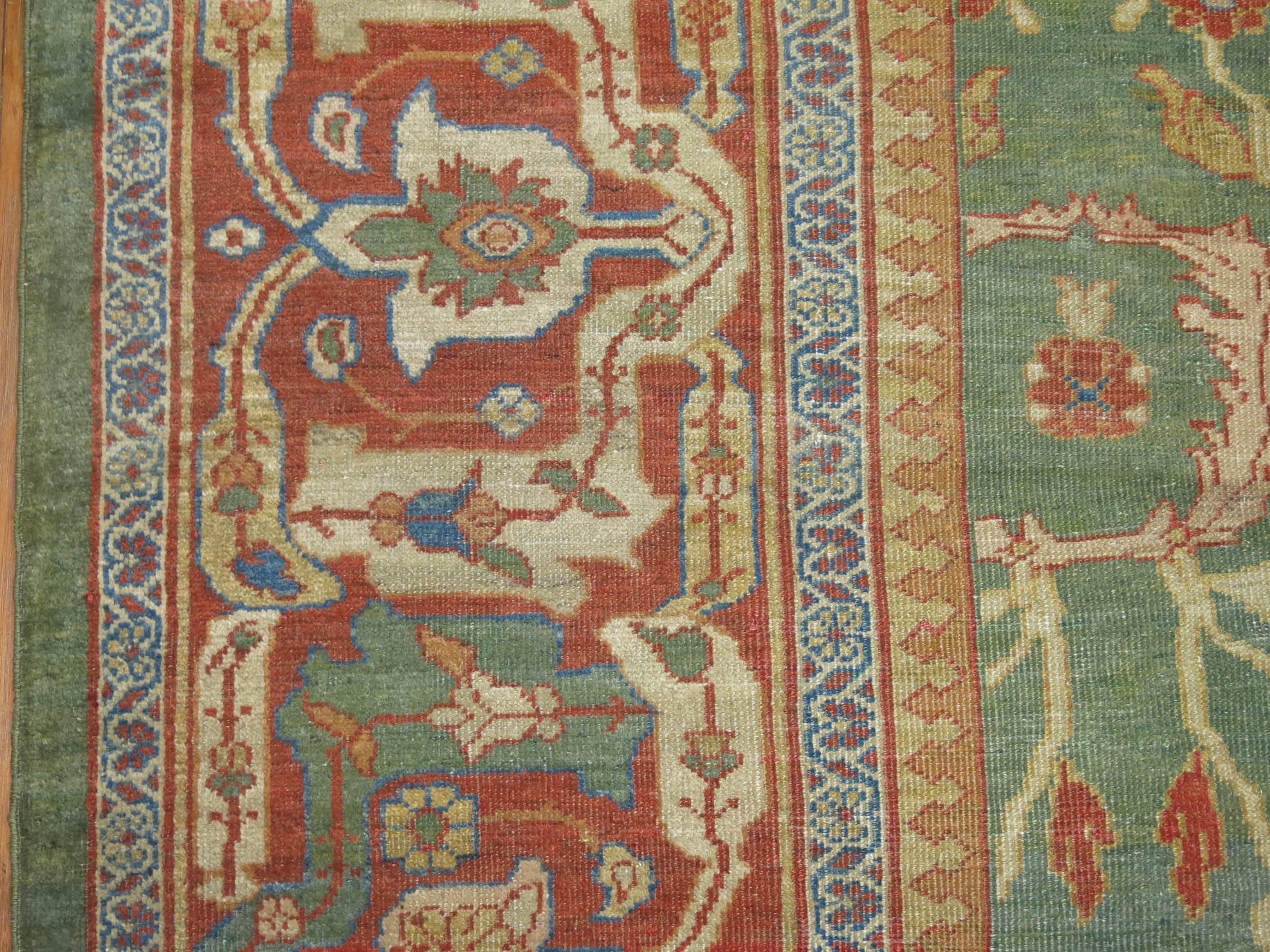 Exquisite Persian Sultanabad rug with a green ground and red border.

Often the finest in the Sultanabad antique carpet style render spacious, very unique variations upon classical Persian all-over patterns, glowing pastels and earth tones. Most