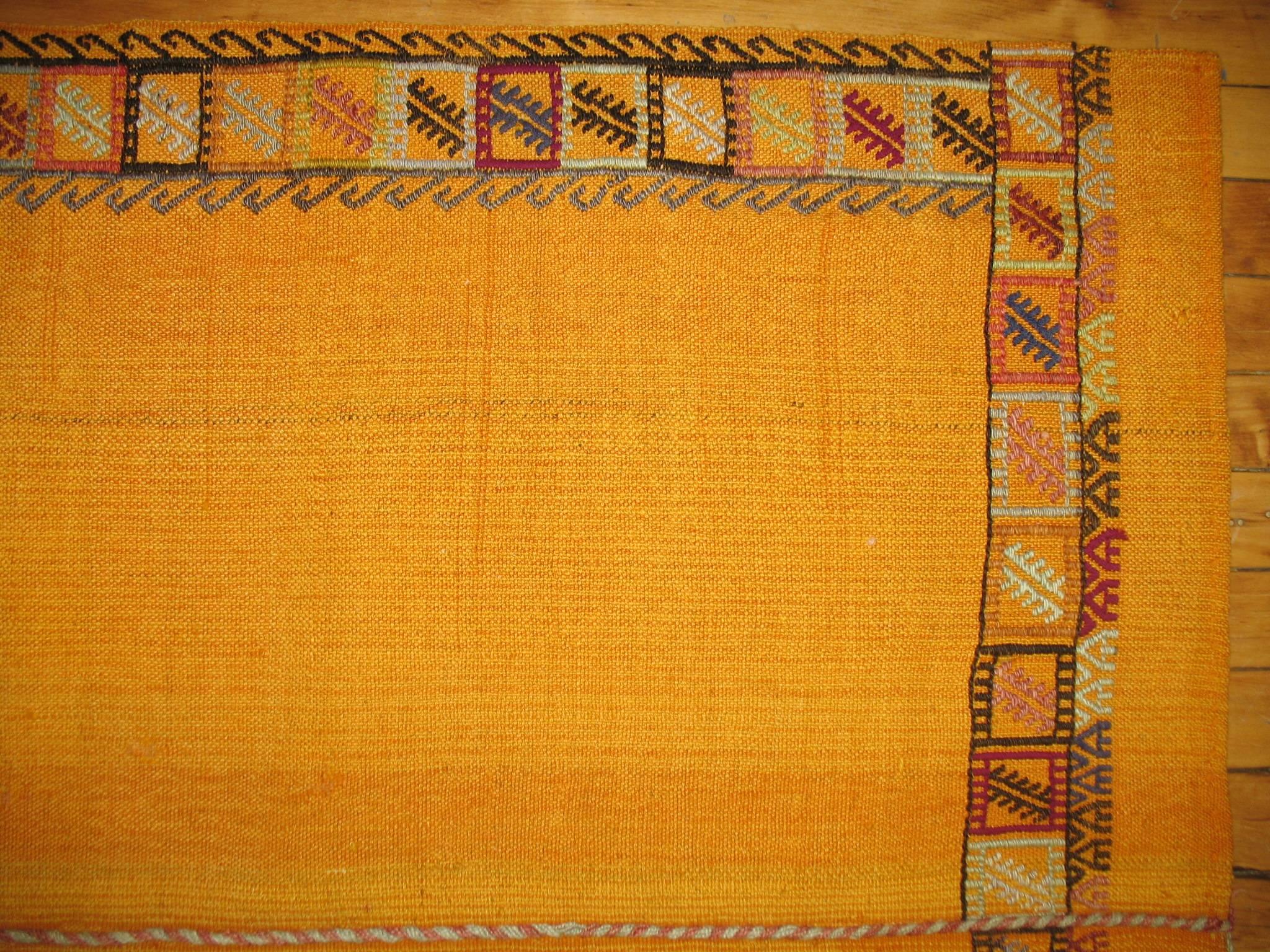 Throw square size flat-weave with a plain solid design in goldish yellow surrounded by a tribal border.
