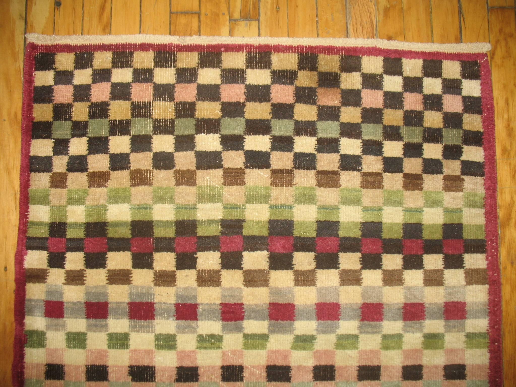 Mid-Century Turkish deco runner with an all-over checkerboard design. Plum , green, brown, pink and ivory acccents are dominants

3' x 6'9''