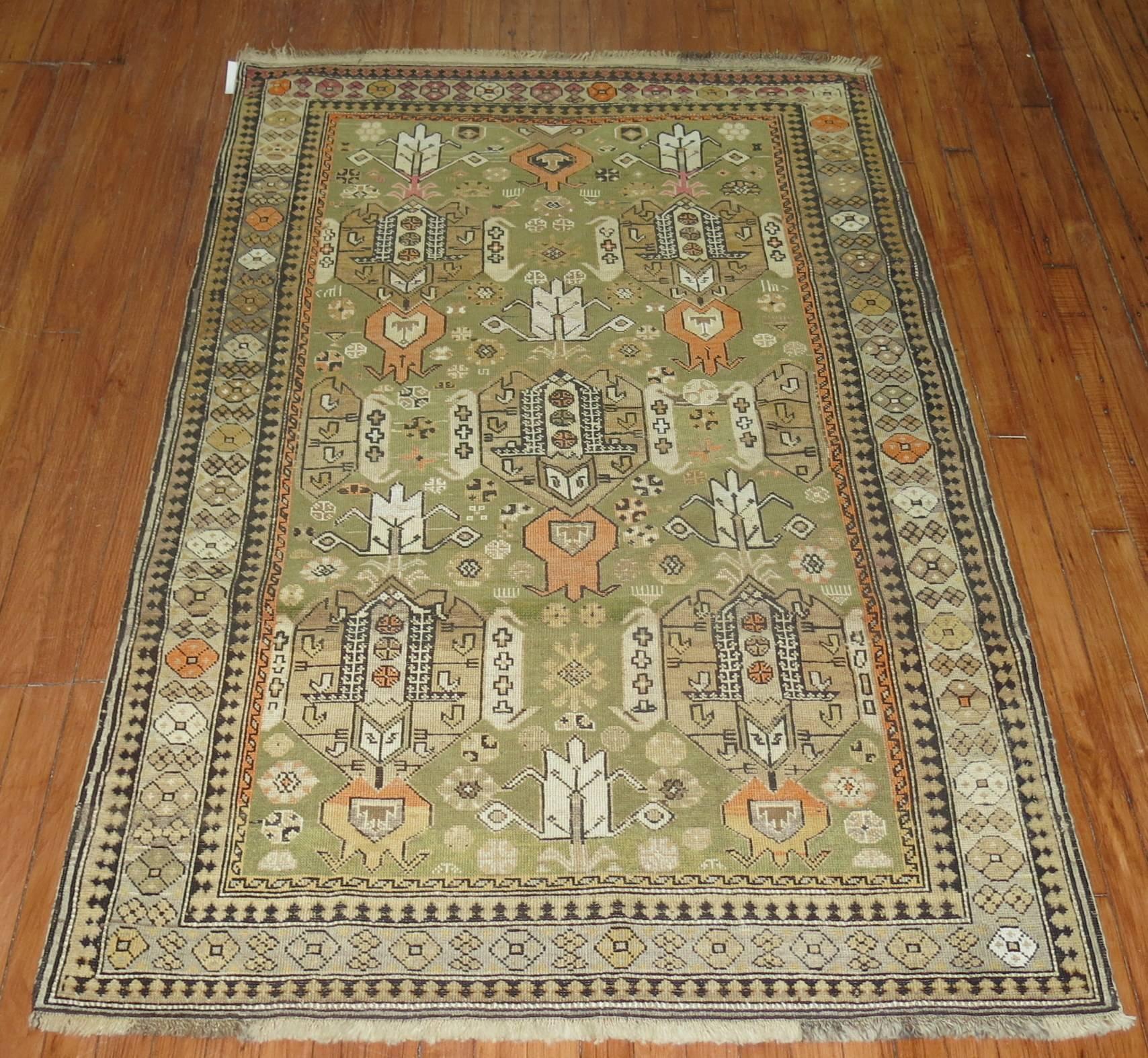 An early 20th century Caucasian rug with an unusual pea green field.