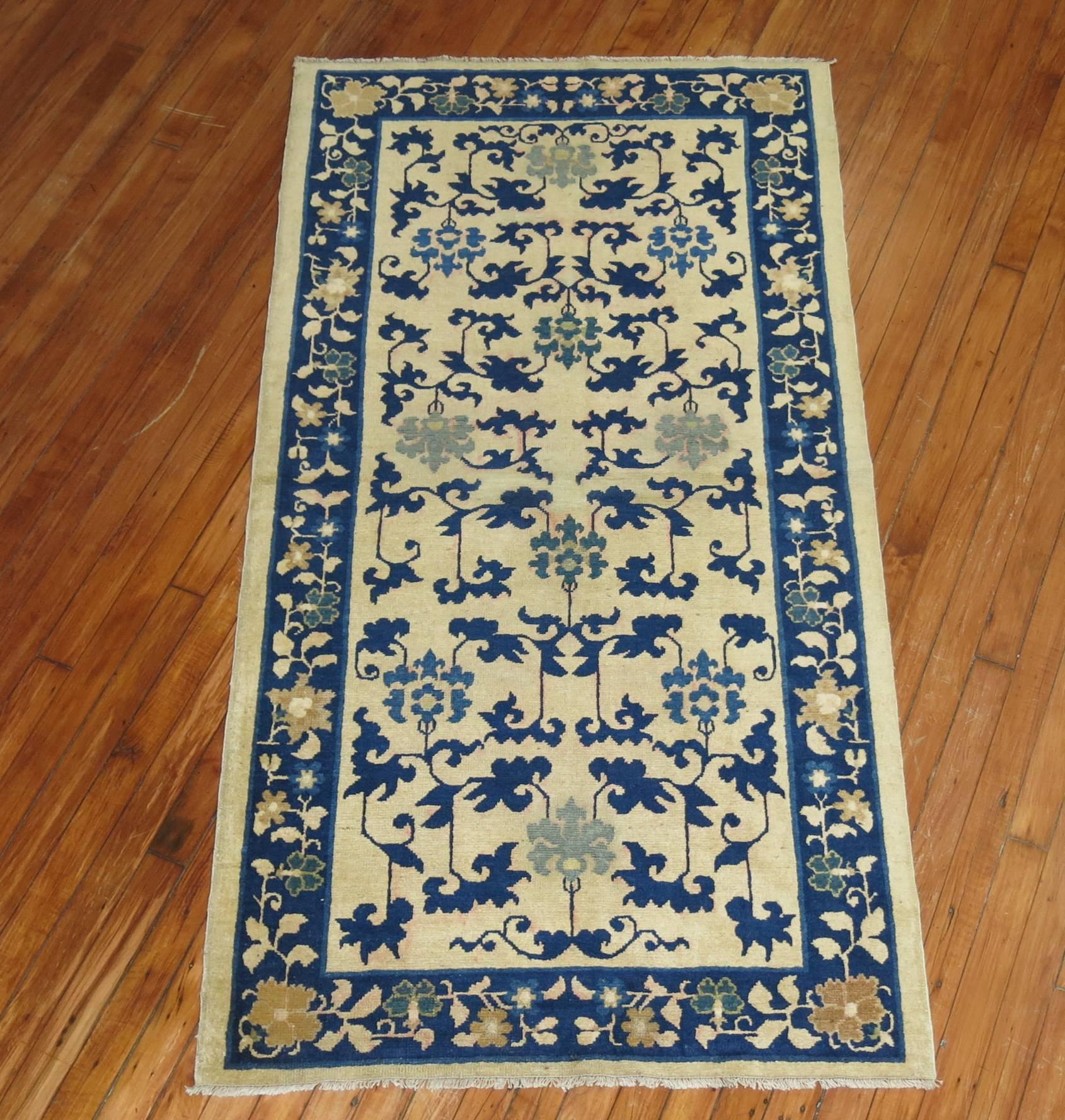 An early 20th century Chinese peking throw rug. Cream field with blue accents. 

3' x 5'10''