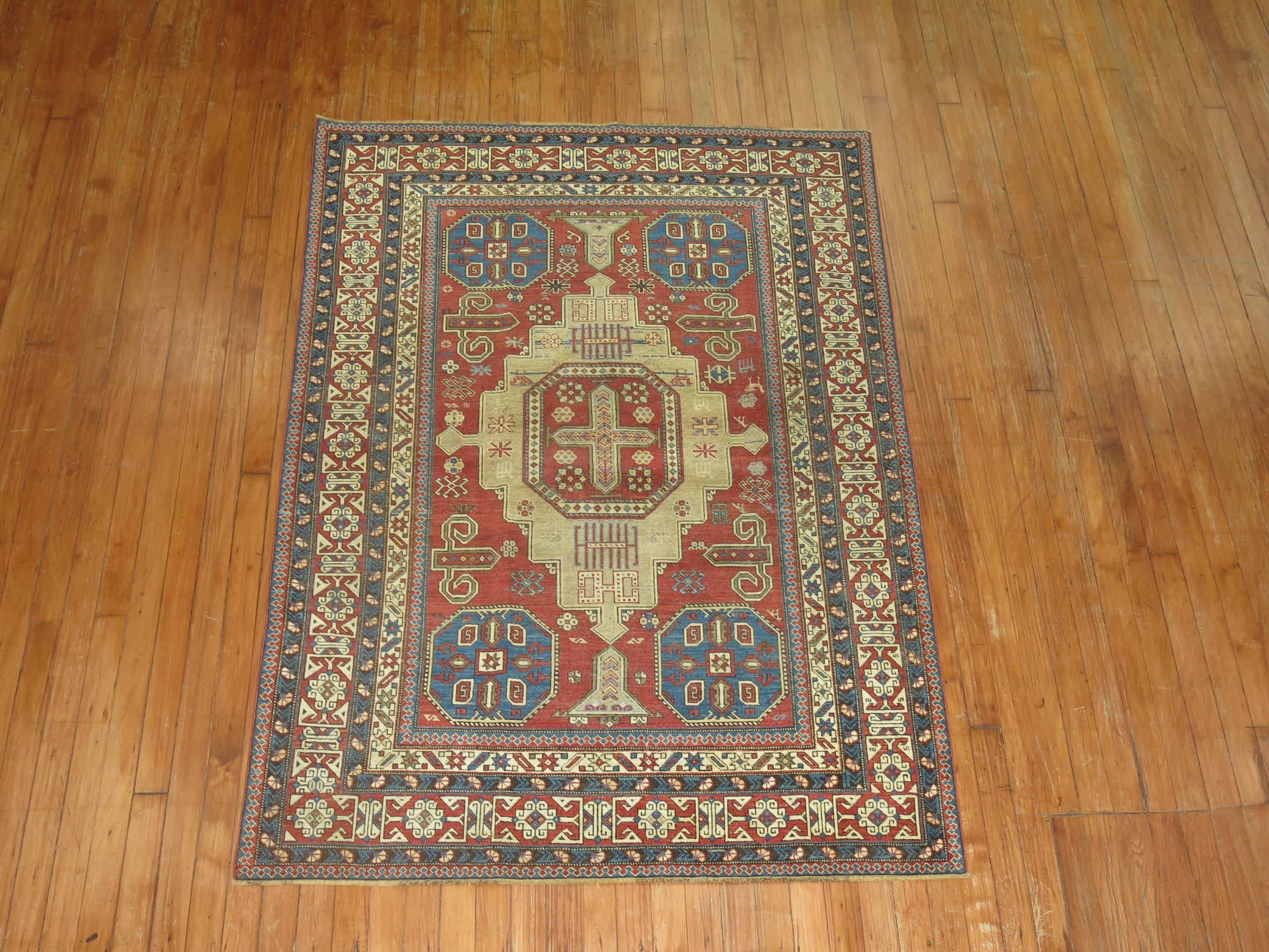 An early 20th century Antique Caucasian Shirvan rug with a camel color medallion on a soft brick red field and multi band border.

Antique Shirvan Caucasian rugs of this caliber ceased to be produced around the turn of the 20th century. With the