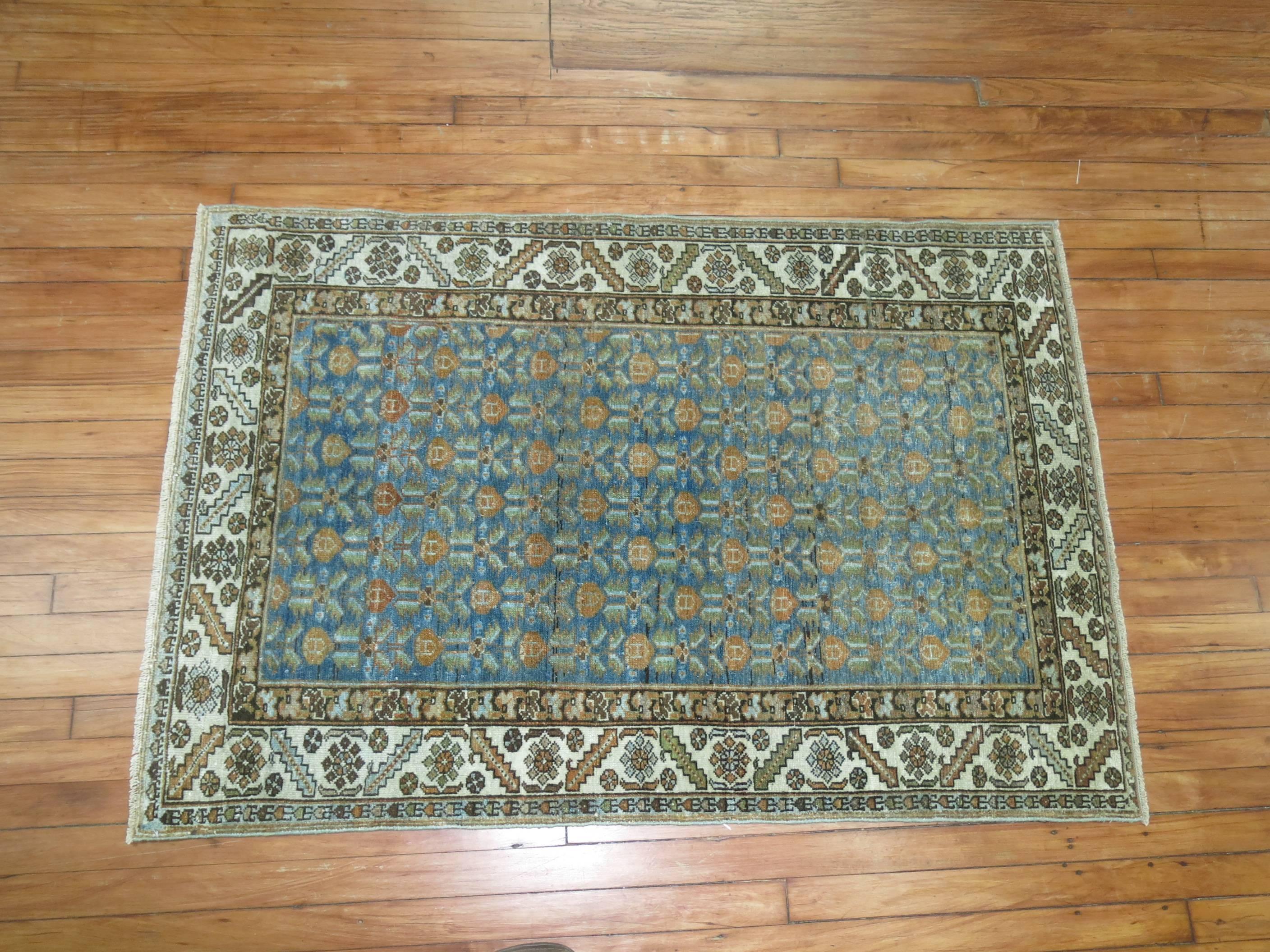 An antique Persian Malayer rug in soft blues and soft peach.