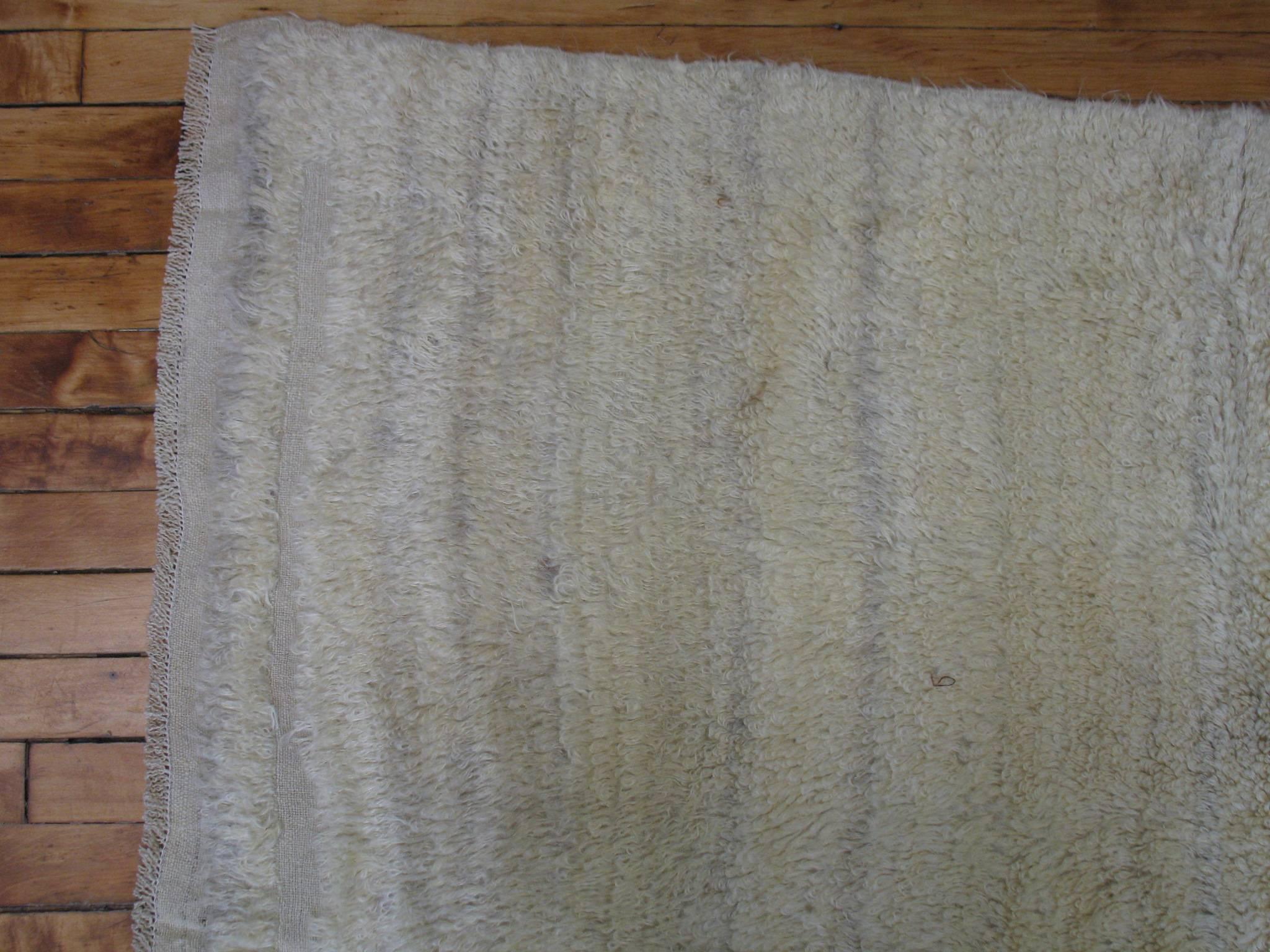 A midcentury Turkish long pile rug having an open creamy yellow field. Pics seen are with and without a flash.

Measures: 4'9