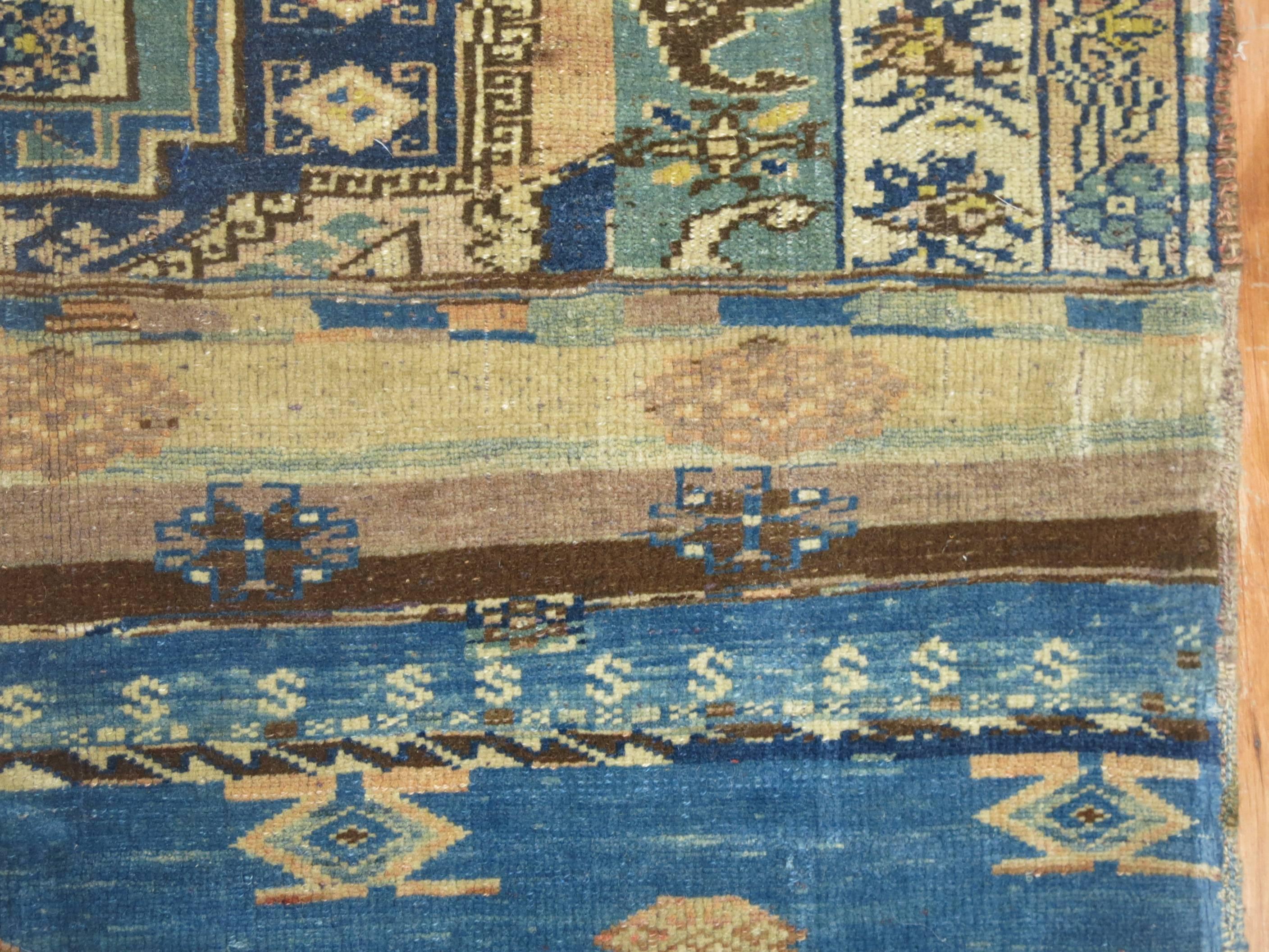 A vintage Turkish sampler rug in predominant camel, blue and greens. At first weavers constructed samplers, also known as Wagirehs, which acted as a blueprint for larger carpets. The finished weaving's were of fine quality and outstanding colors.