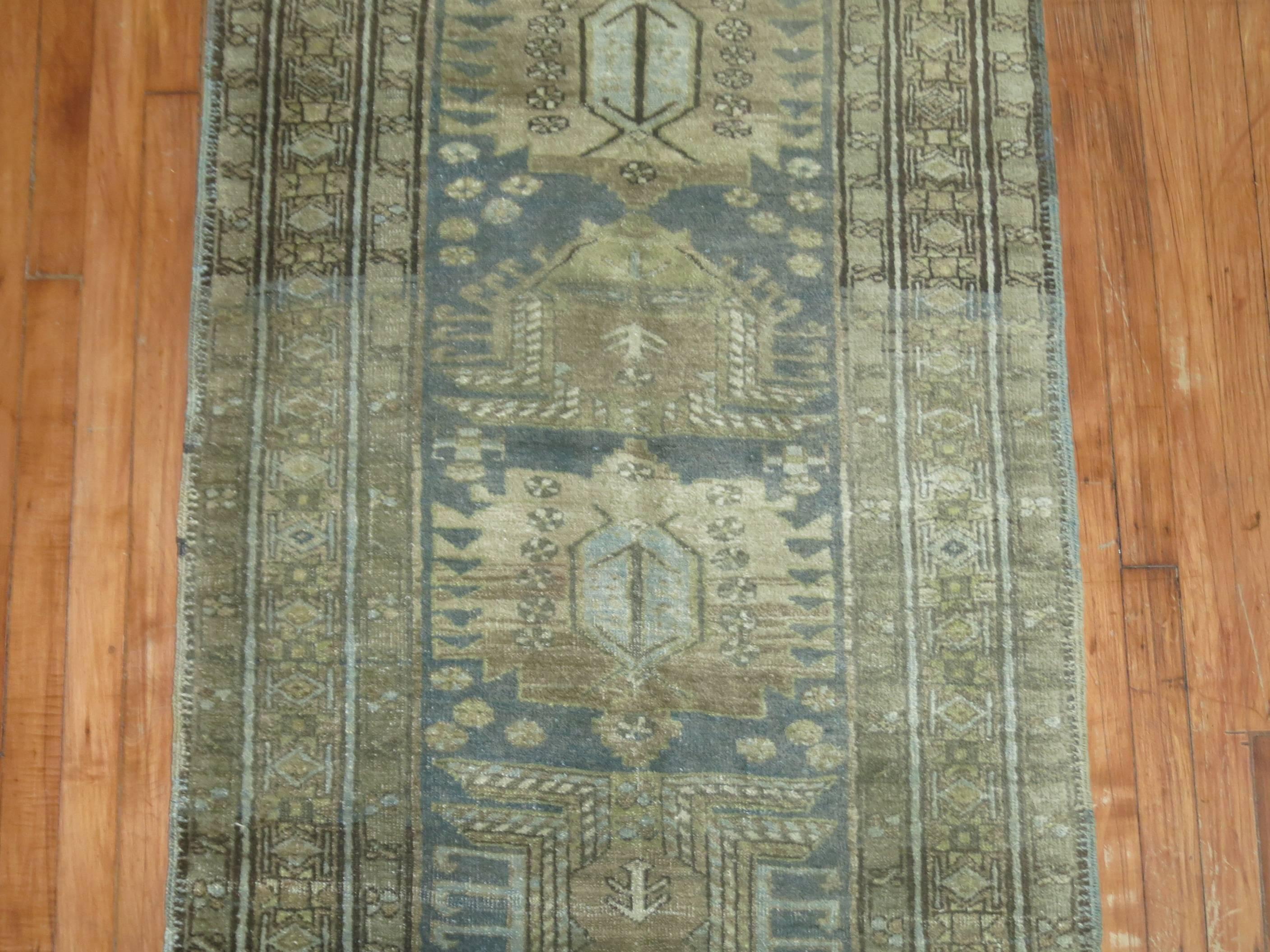 An antique Persian Heriz runner in faded blue, green and brown accents.