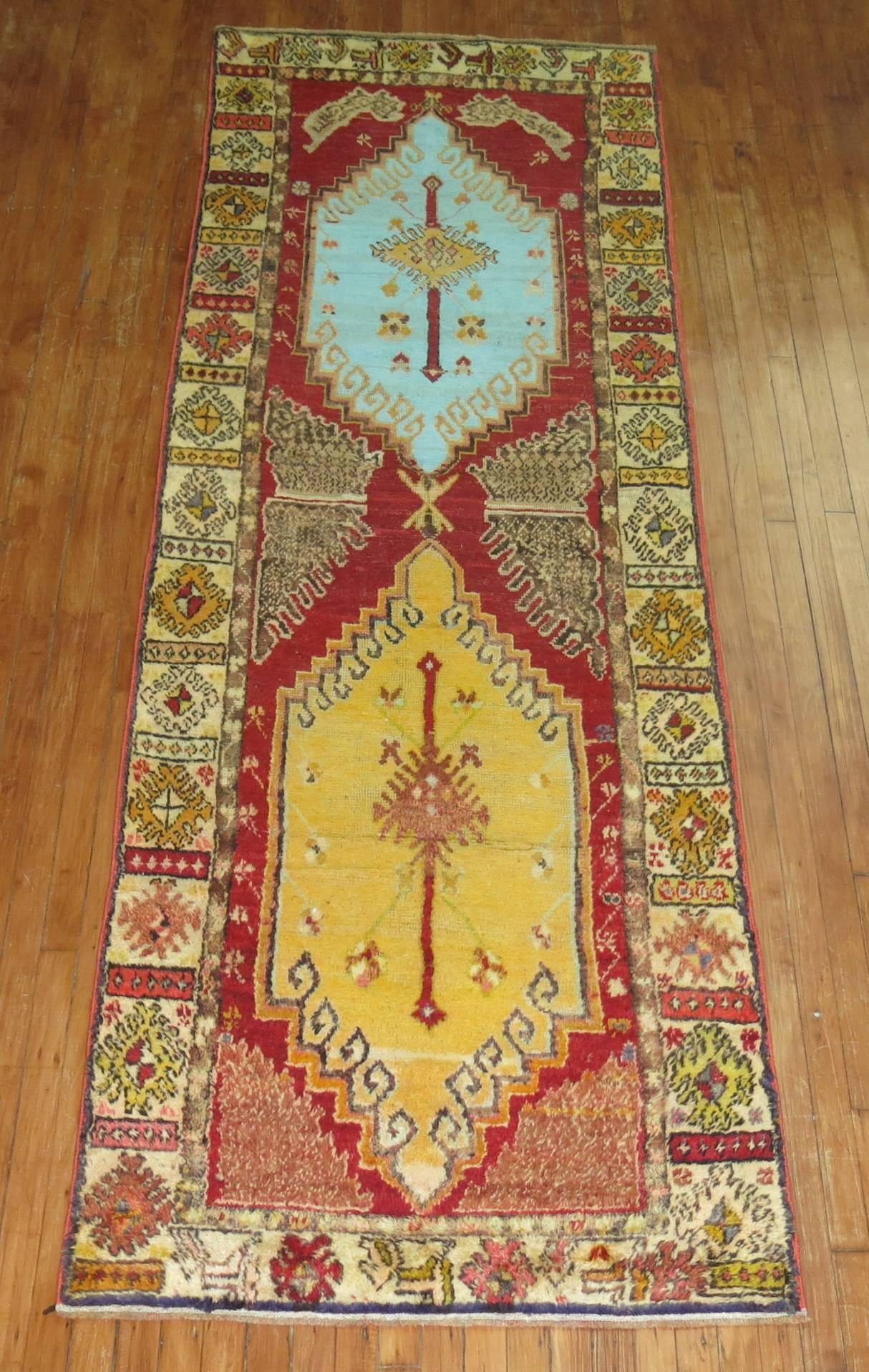 A mid-20th century geometric Turkish runner featuring bright colors with one medallion in an electric blue color. The field is a bright red. Condition and pile are very good

Measures: 3'4