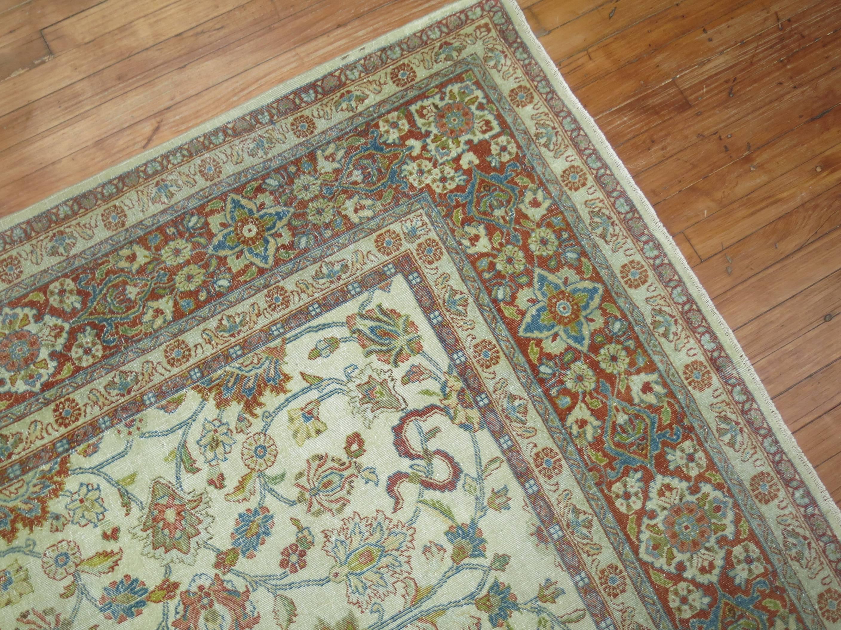 An early 20th century Persian Kashan rug consisting of an ivory field with soft accents in blue, green and red.

8'5'' x 11'5''