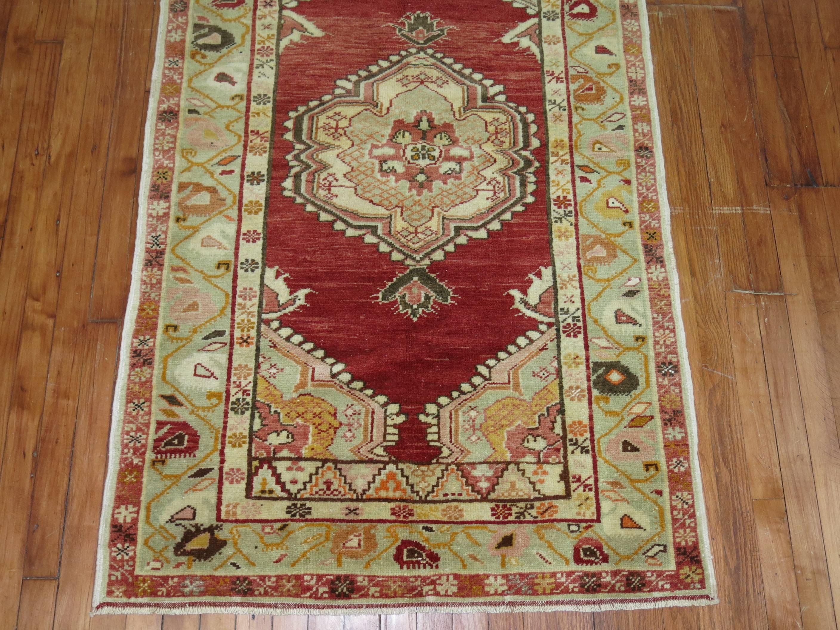 Classic Turkish Oushak rug with centre medallion and multiple borders on a red ground.
