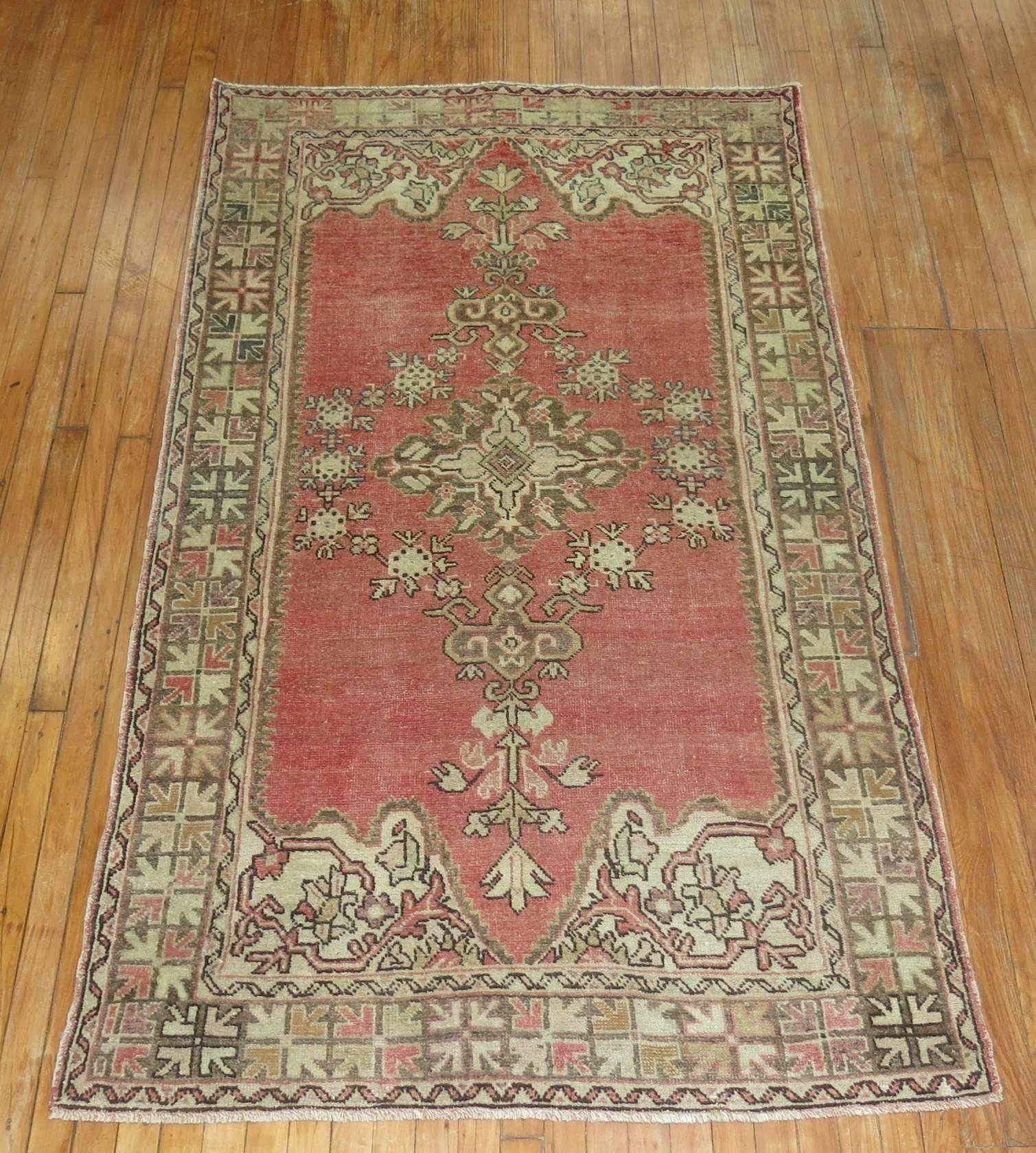 Vintage Turkish Oushak rug in soft reds, accents in brown and ivory.