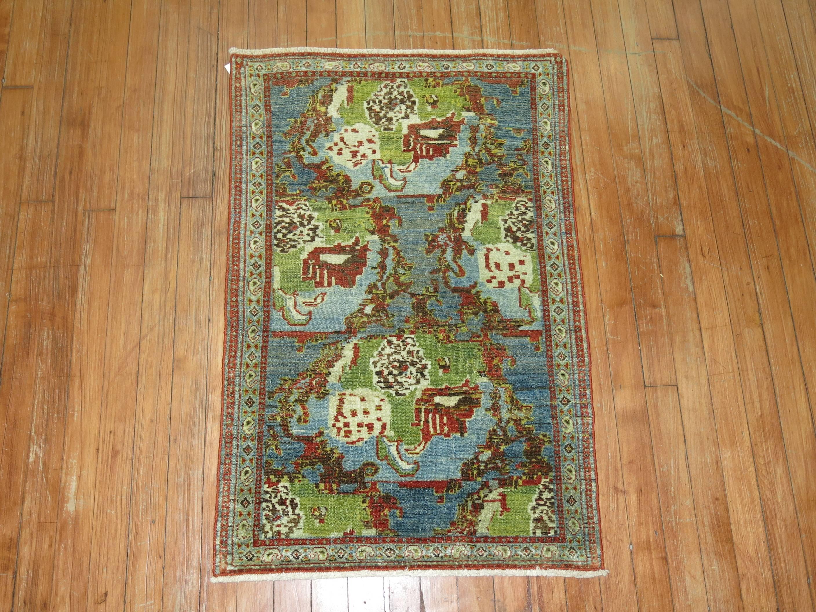 An early 20th century Persian Bidjar or Senneh rug featuring a Gol- Farang design, dominant accents in sky blue and chartreuse.

Measures: 2'1'' x 3'2''.