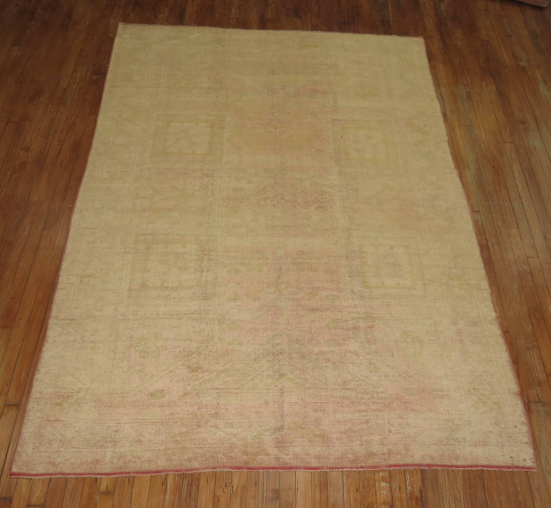 Mid-20th century Turkish Oushak rug in pale salmon and gold.

Size: 6'4” x 9'3”

Antique Turkish Oushak carpets such as these are desirable today as highly decorative pieces. They are notable for the grand, monumental scale of the designs, often
