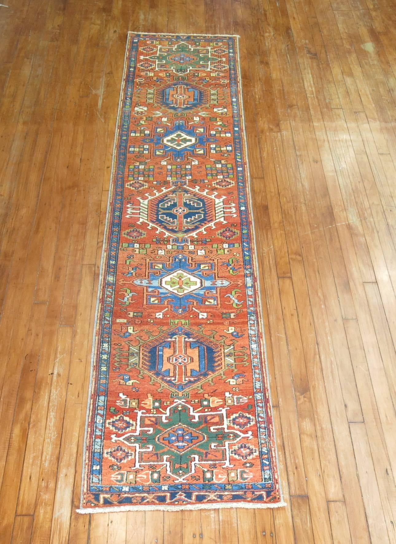 Narrow colorful Persian Heriz karadja runner

The best antique Heriz carpets are found in their design style and vivacious colors. The signature of a Heriz is the large medallion with over-scale corner pieces filled with angular oak leaves and