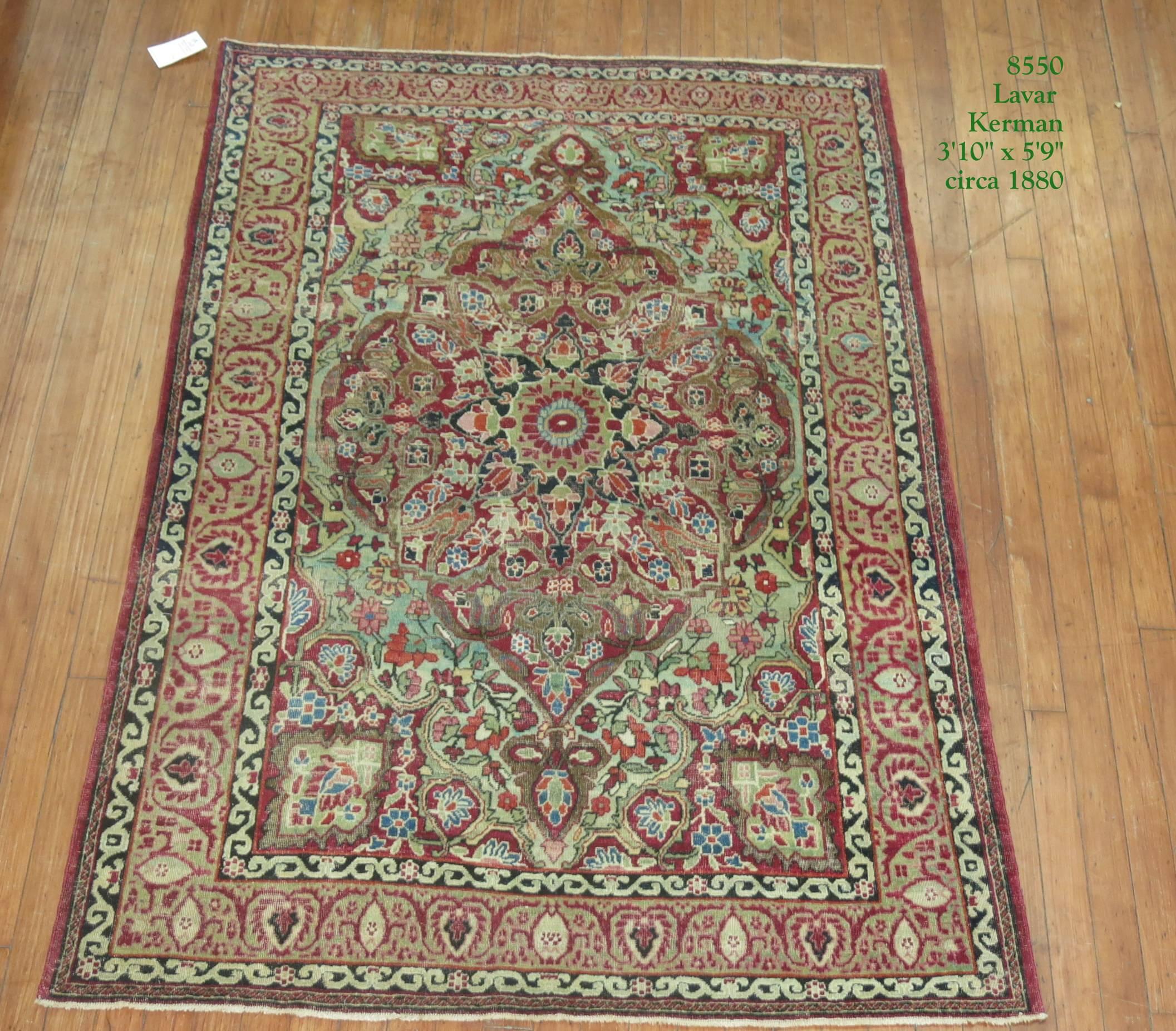 A late 19th century Persian Lavar Kerman rug featuring a tradtiional design in burgundy and celadon green 

Measures: 3'10