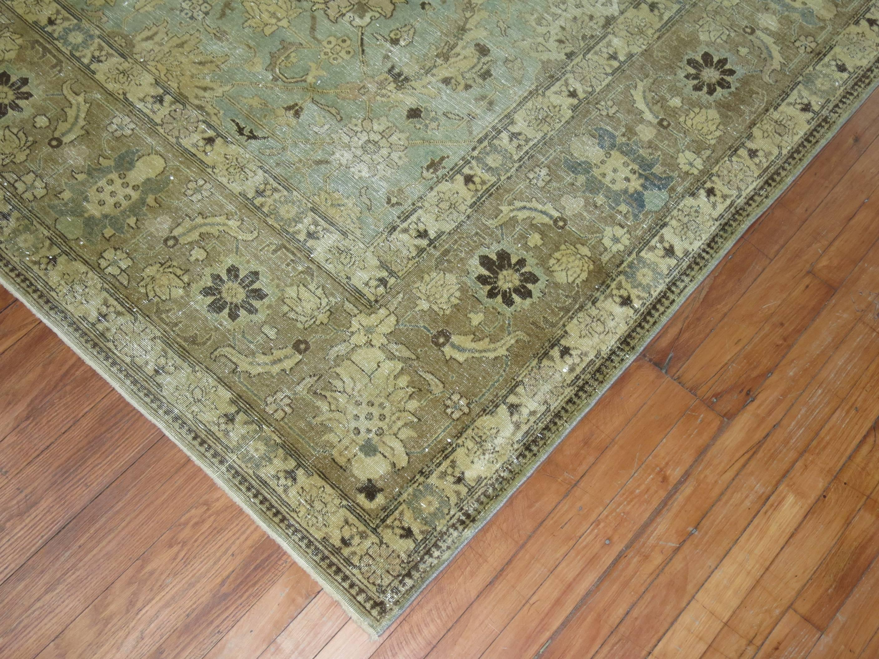 An early 20th century Distressed Persian Tabriz carpet in mint green. Light brown border with some khaki and slate accents

9'5'' x 12'9''