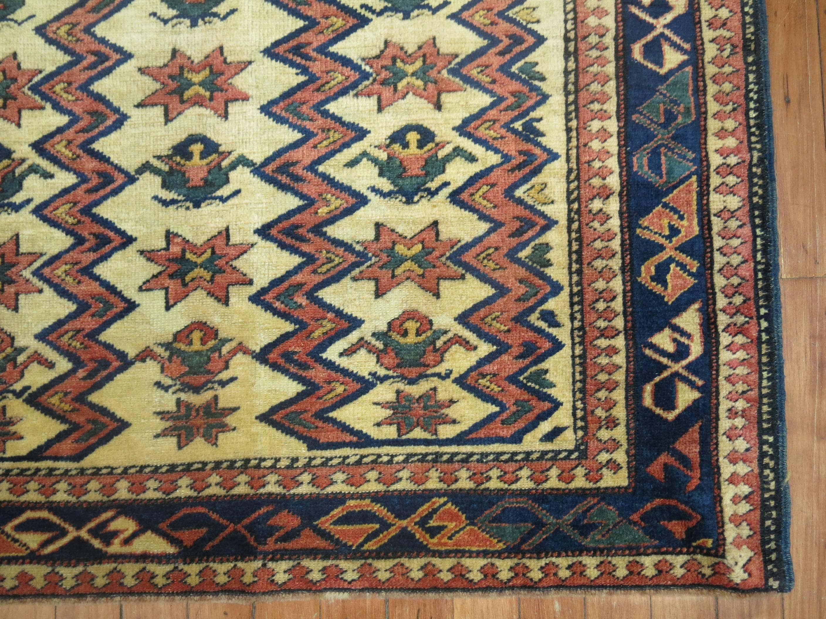 Un tapis Shirvan caucasien ancien de taille carrée du 20ème siècle. Accents vert olive, rouille, marine sur un champ beige.

Mesures : 3'5