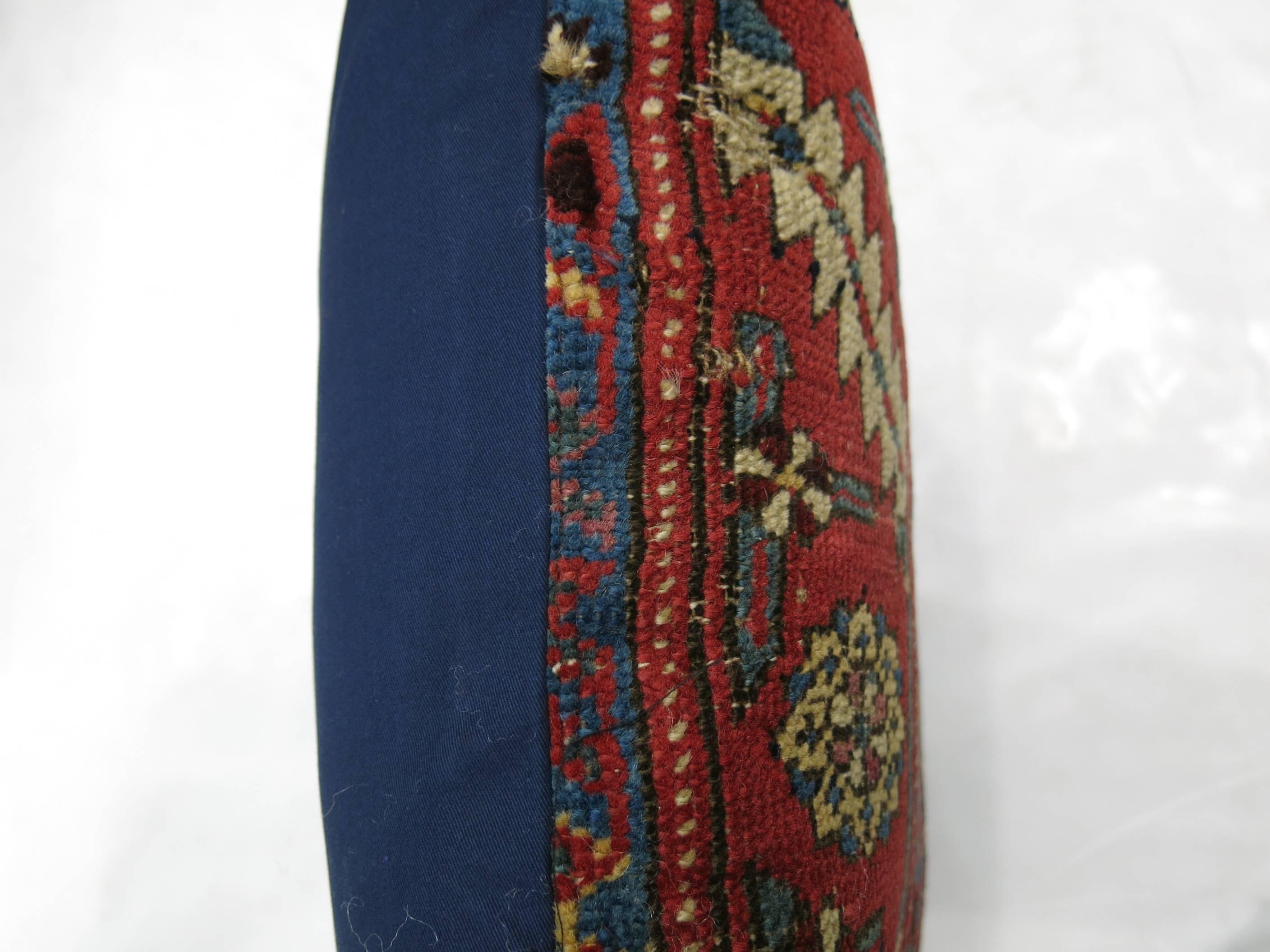 Pillow made from an antique Persian rug backed in blue.

17'' x 18''