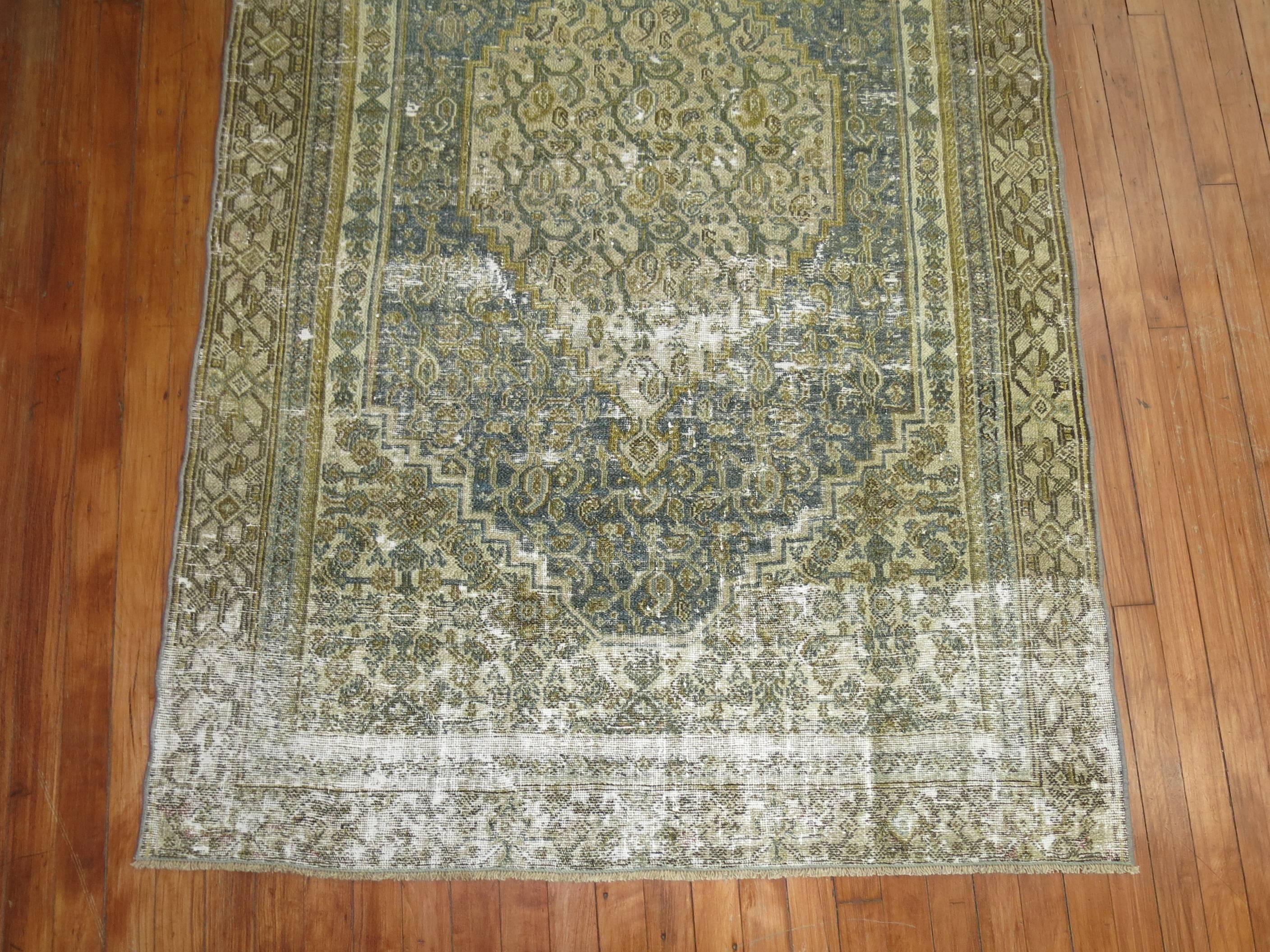 A perfectly worn Persian geometric Bibikabad rug in green, gray and gold.