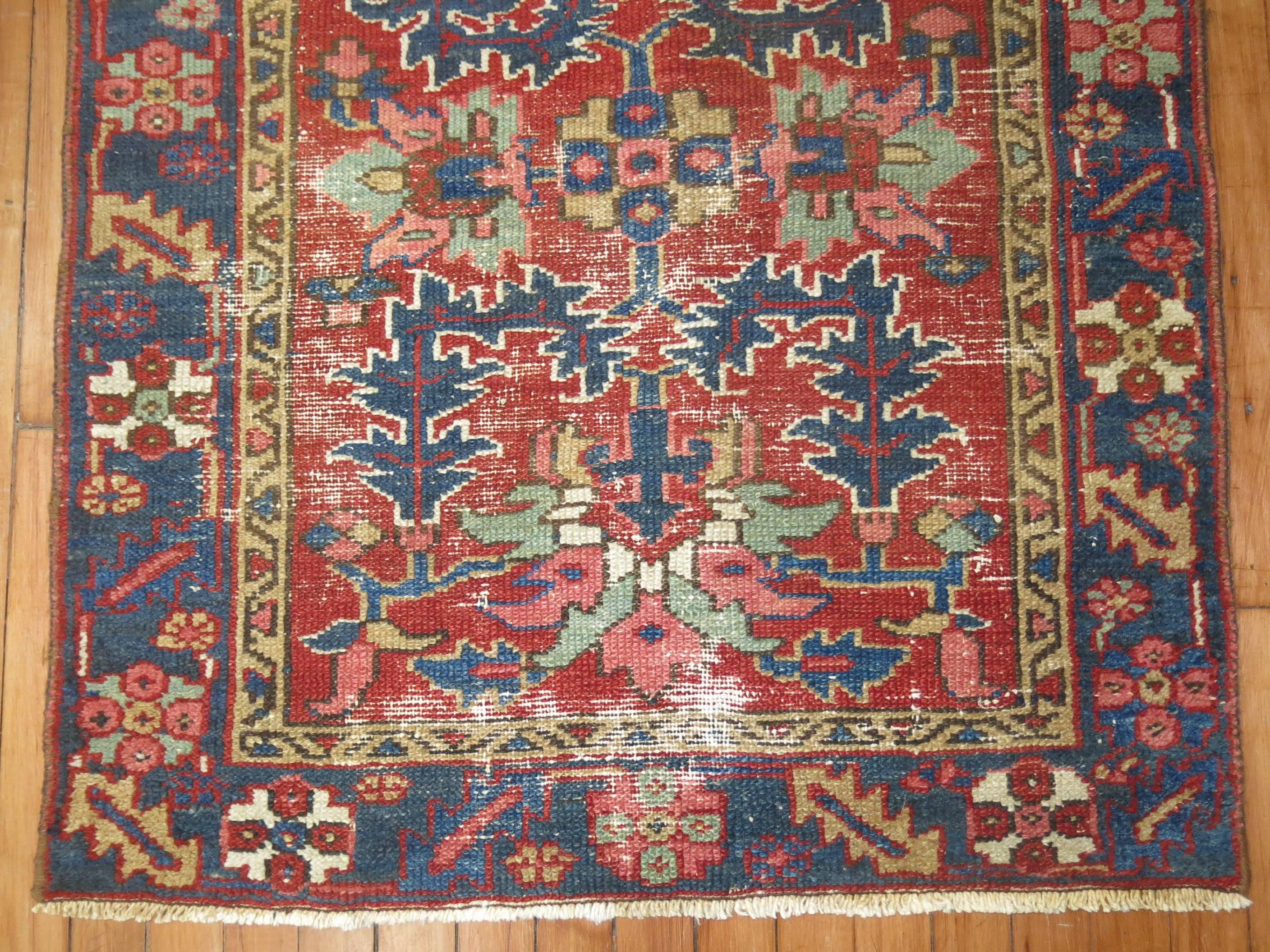 Square size Persian Heriz throw rug in vivid reds, greens and blues.