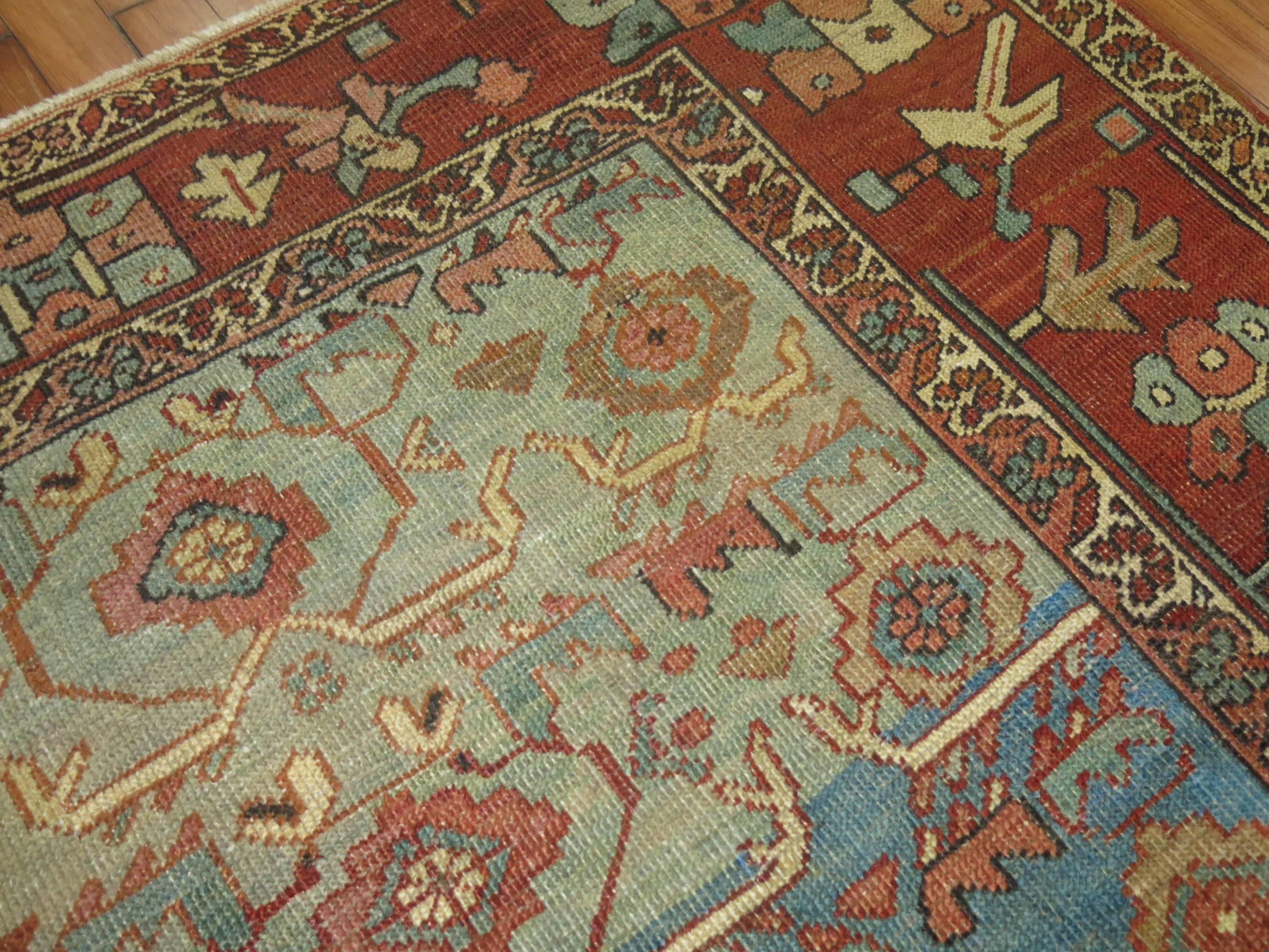 A decorative Persian Heriz with an abrashed blue ground and brown border.