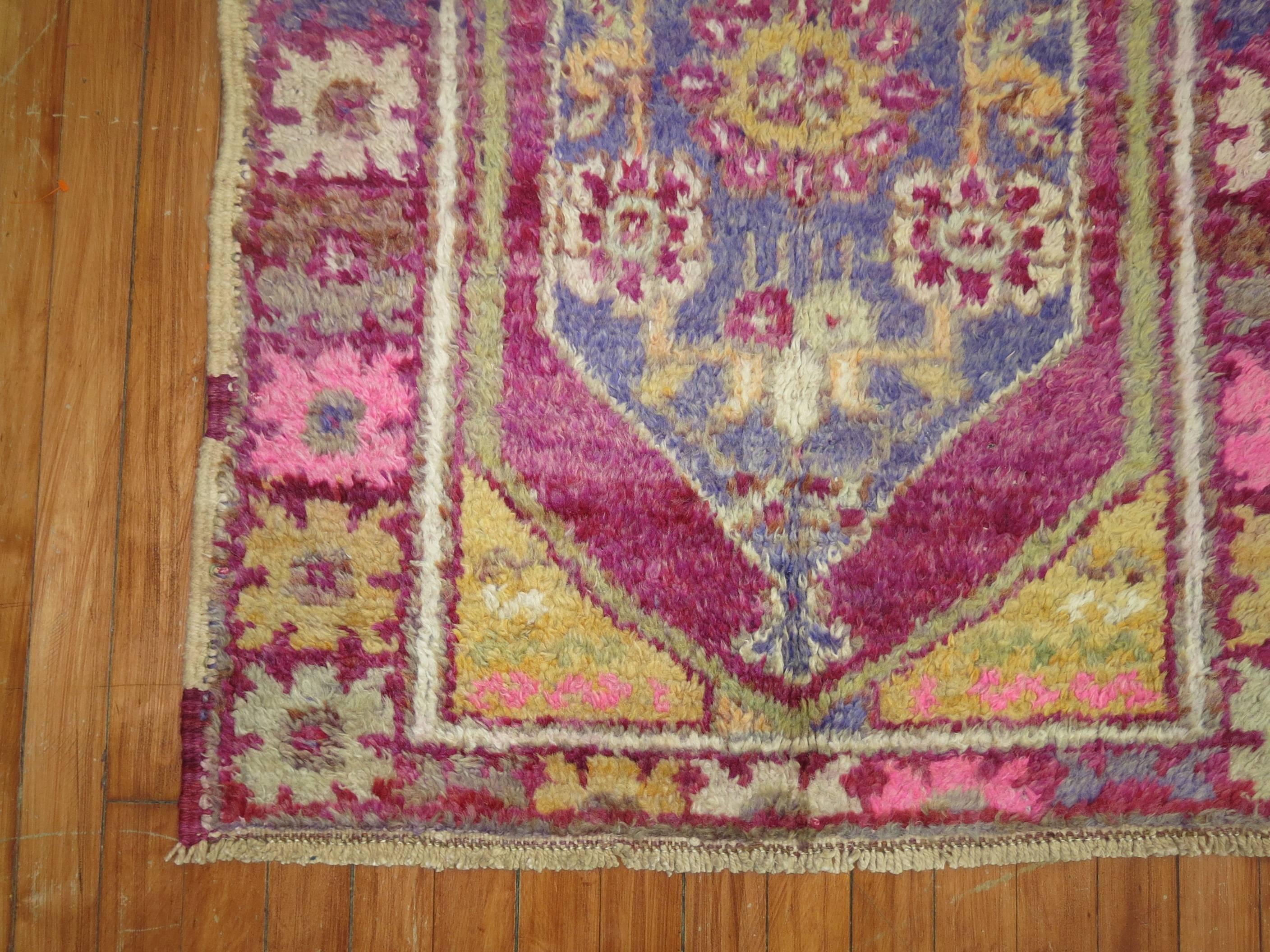 Wild pinks and purple highlight this vintage Turkish Anatolian rug.