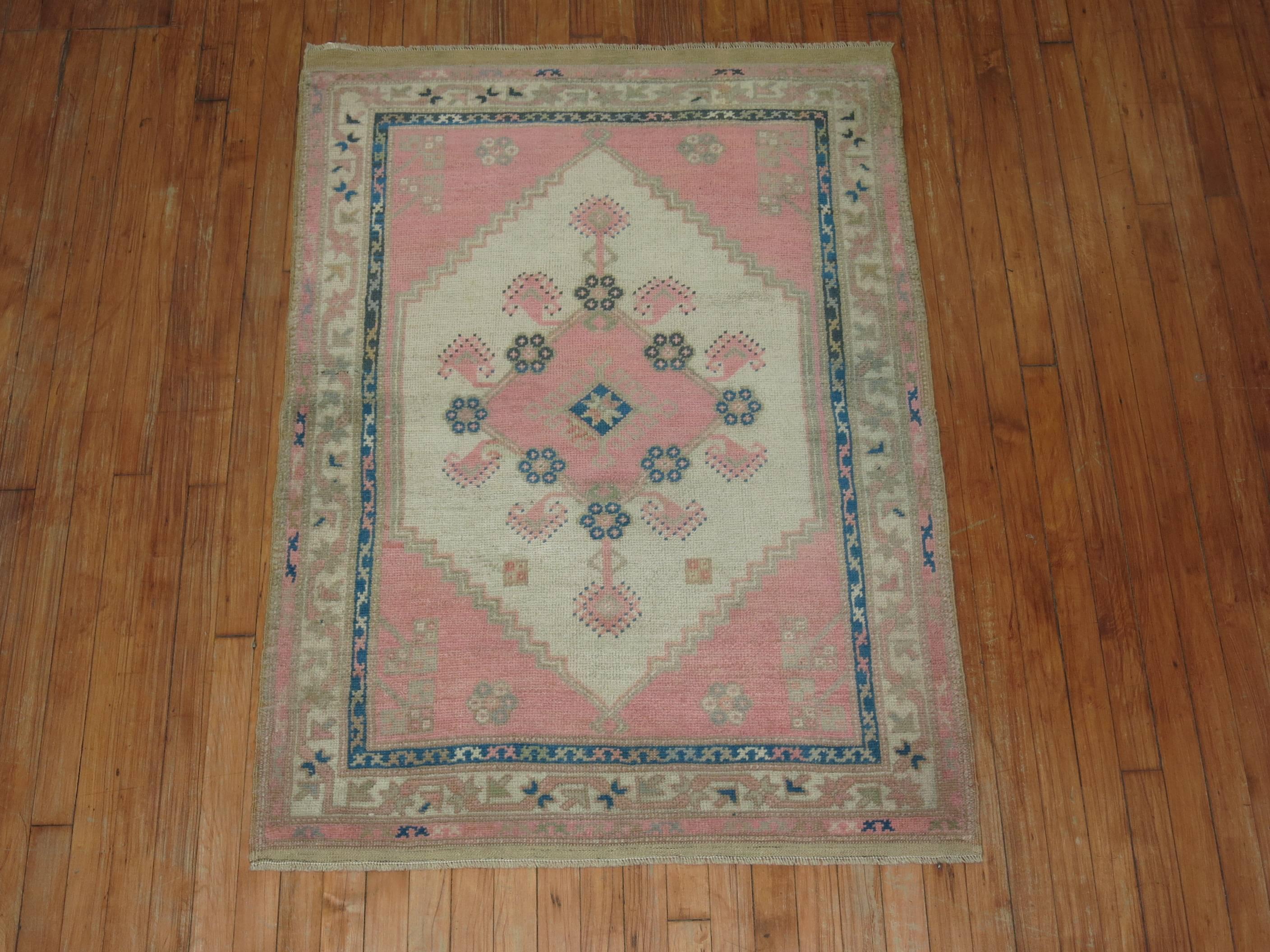 Mid-20th century Turkish Anatolian rug featuring a bubble gum pink color we seldom find. Pretty Blueish green accents with an ivory medallion.

Measures: 3'3