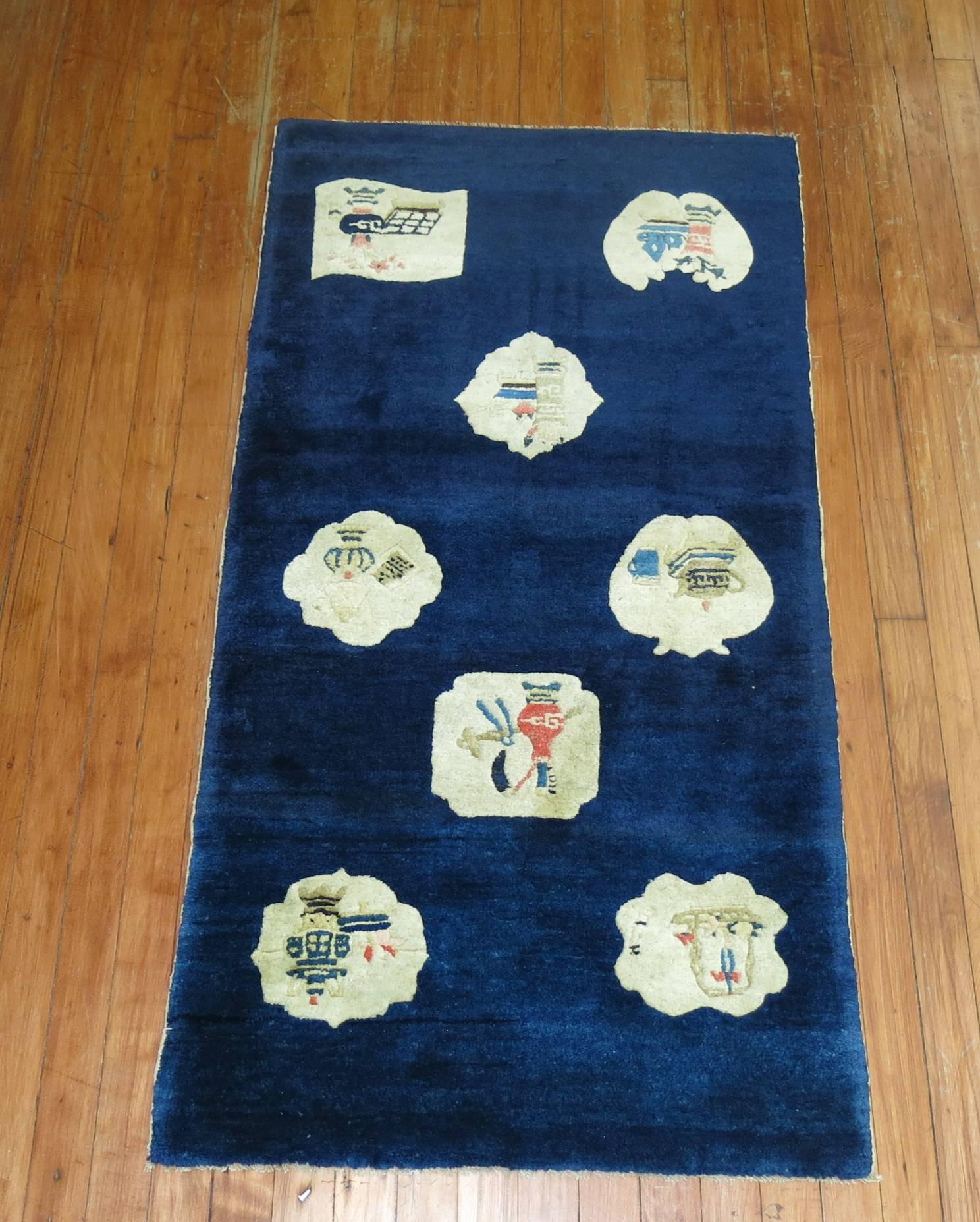 A folksy early 20th century Chinese Peking rug featuring eight irregular shaped elemental motifs on a midnight blue colored ground,

circa 1930. Measures: 2'3