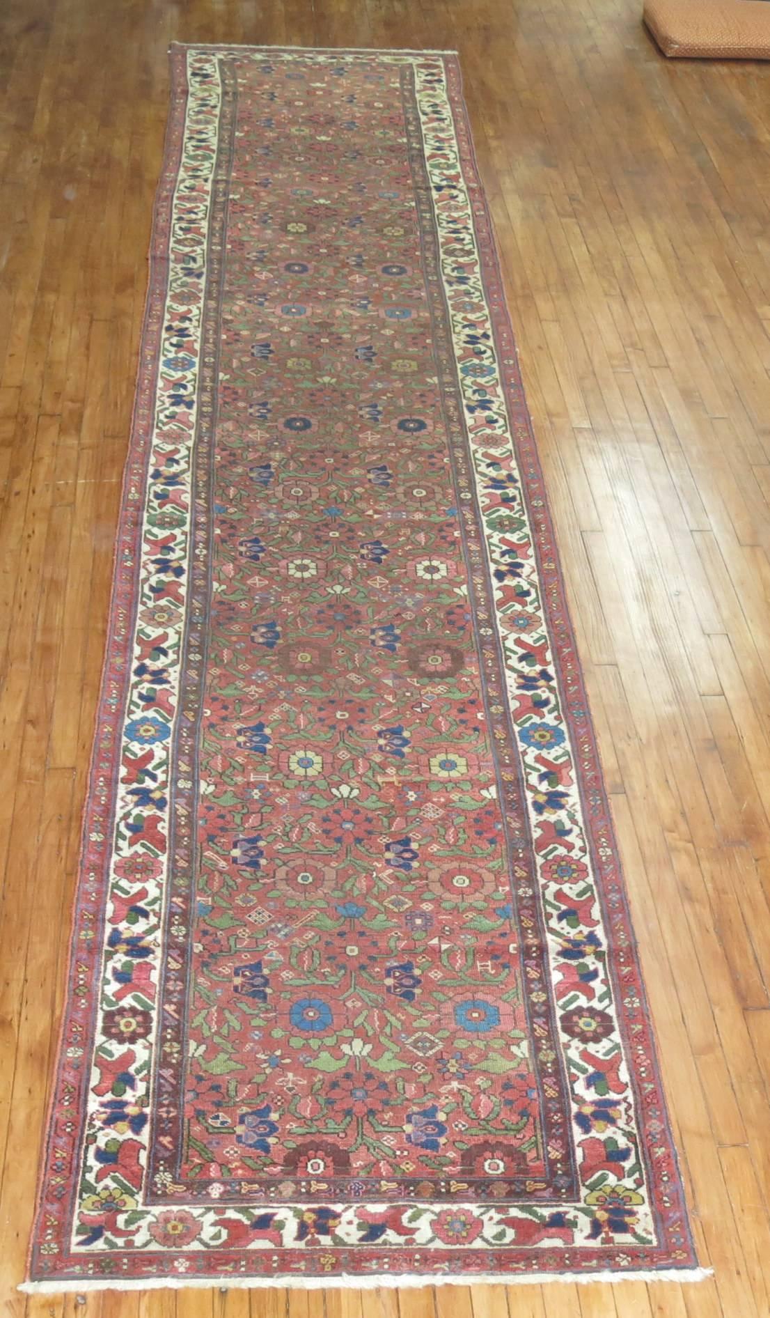 A runner from an early 20th century Persian Malayer Runner. Brick ground with an array of colorful dominant accents in navy, yellow, and celery green

Measures: 3'7