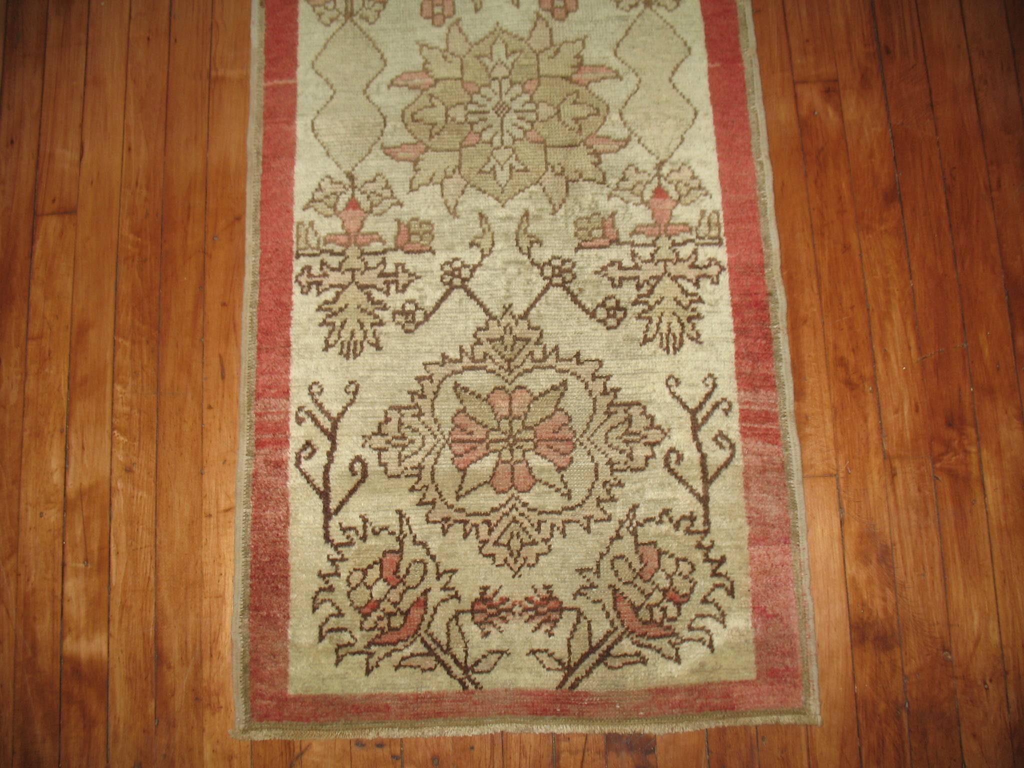 Narrow and short vintage Turkish Anatolian runner with accents in pinky rose, ivory and brown, circa 1940.

Size: 2'2” x 7'6”.